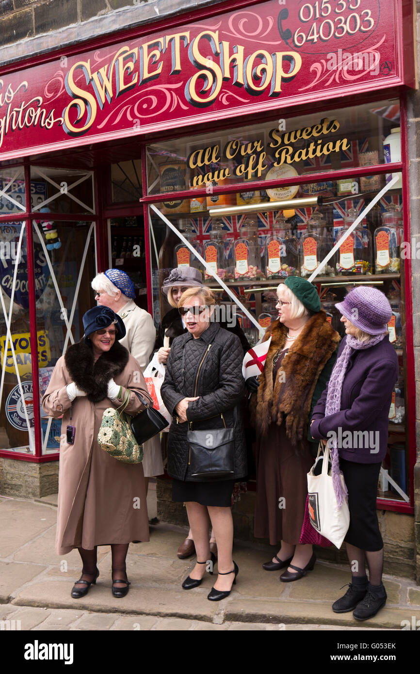 Großbritannien, England, Yorkshire, Haworth 40er Jahre Wochenende, Kunden im Kostüm außerhalb Sweet Shop Stockfoto