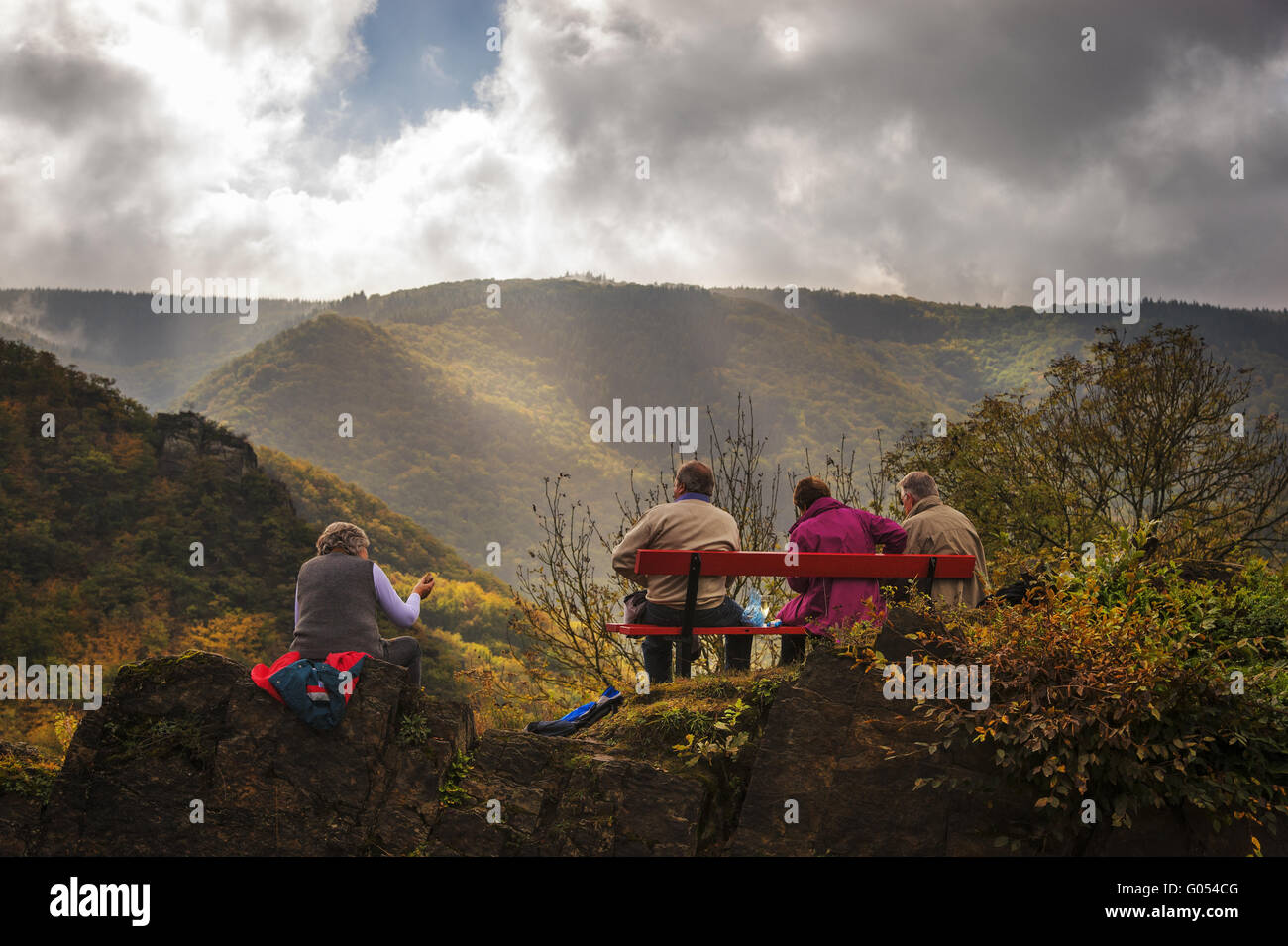 4 Personen ruhen auf einer Bank auf dem Weinlehrpfad Stockfoto