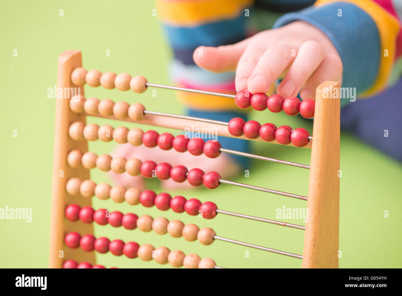 Kinderhand setzt auf Abacus. Konzept der Kindheit lernen, Mathematik und Früherziehung. Stockfoto