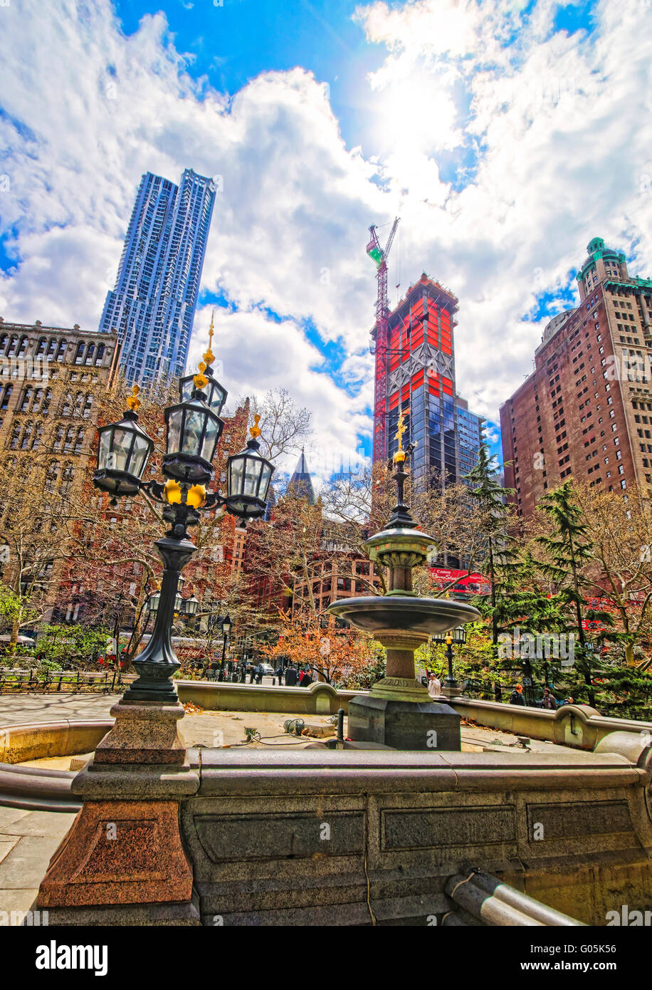 Stret Laterne und Brunnen in City Hall Park in Lower Manhattan, New York, USA. Wolkenkratzer und Touristen auf dem Hintergrund. Stockfoto