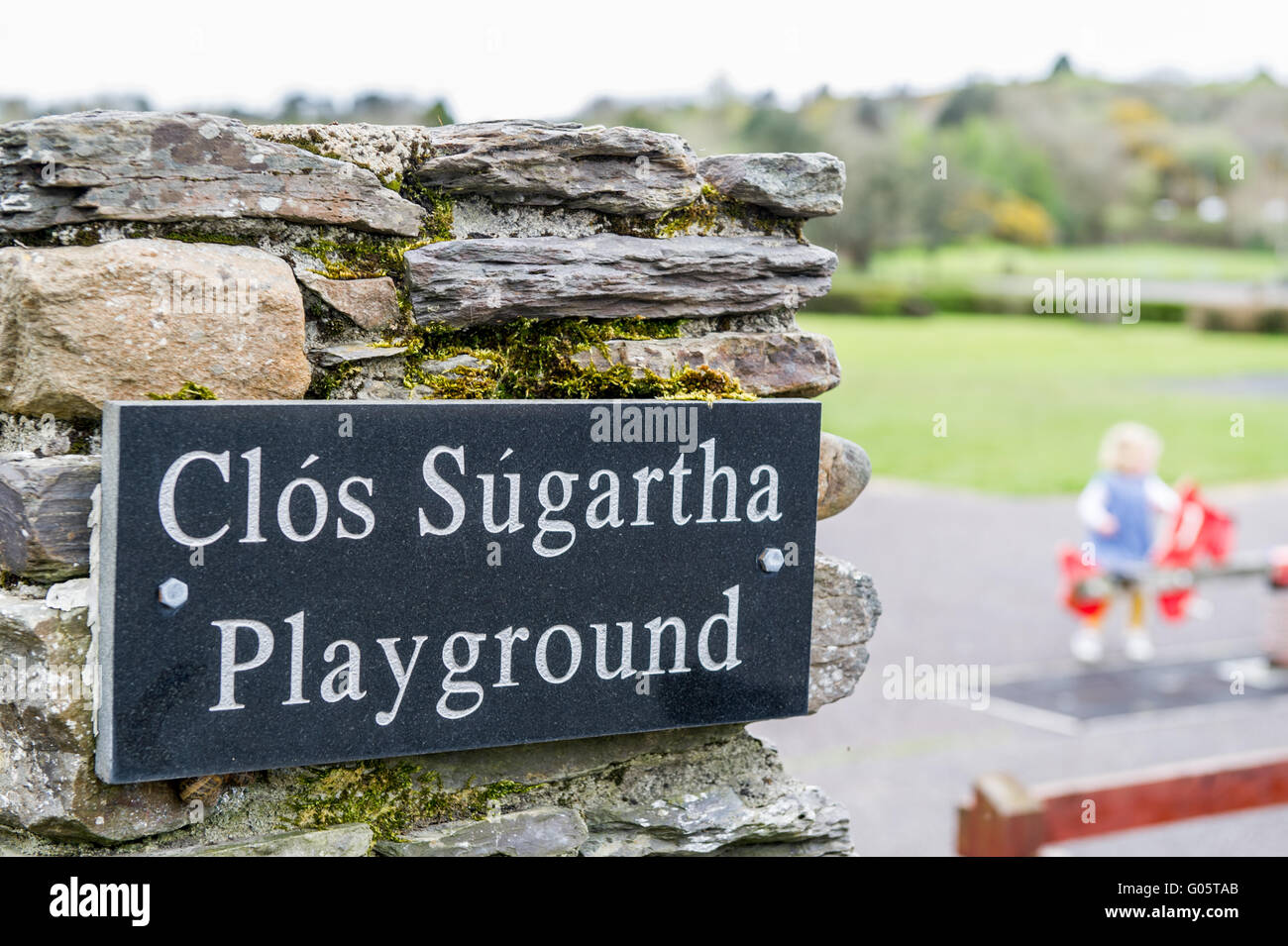 Ein Zeichen für Ballydehob Spielplatz, West Cork, Irland, mit einem unscharfen, Kind im Hintergrund. Stockfoto