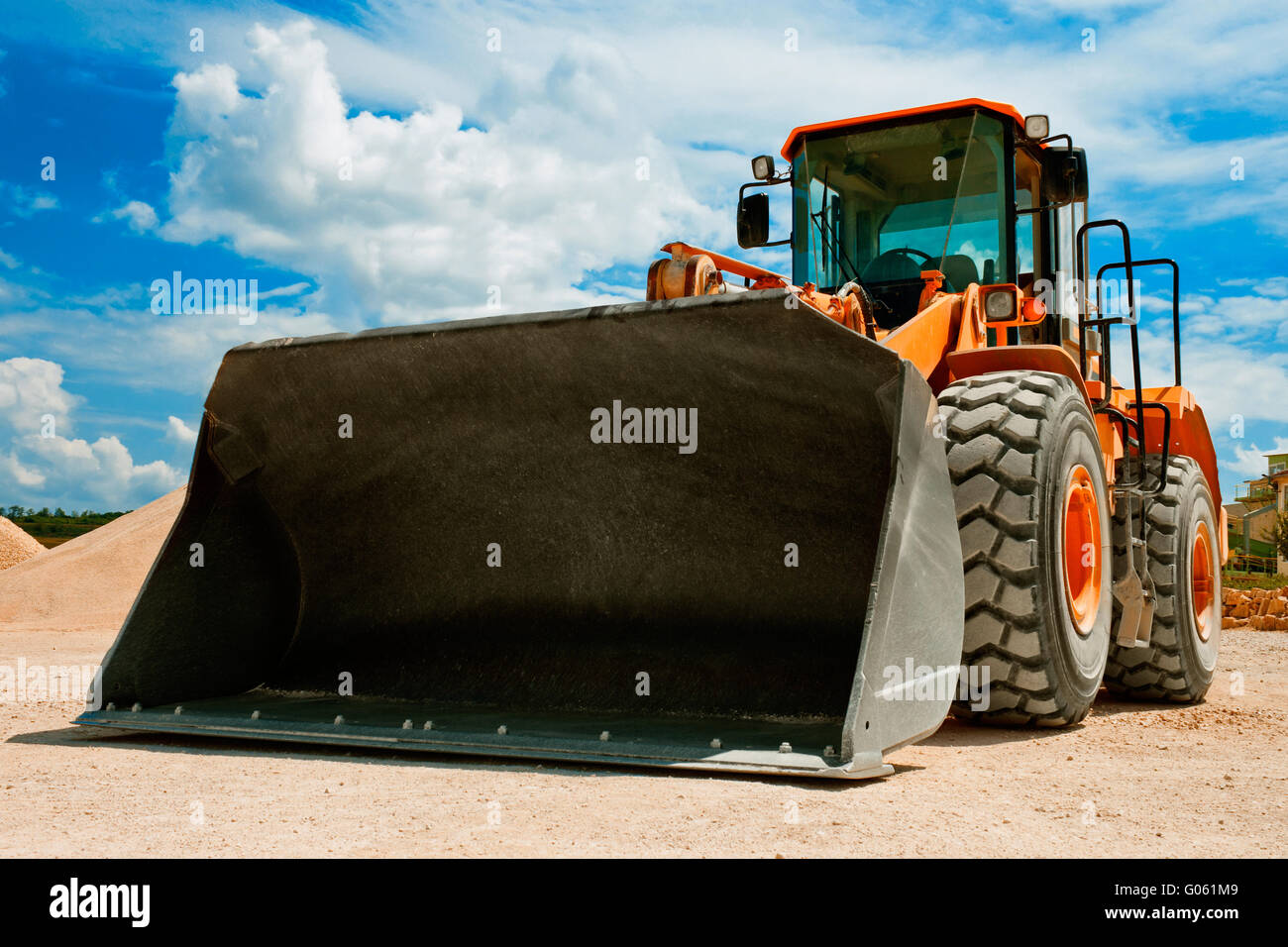 Gelbe Bagger auf der Baustelle gegen blauen Himmel Stockfoto