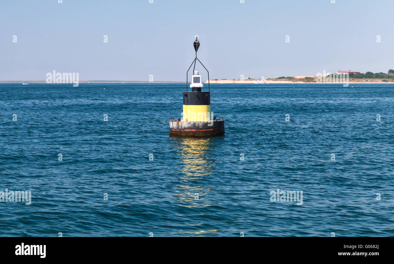 Schwarze moderne Navigation Boje mit gelben Streifen auf einem Meerwasser schwimmen. Kardinal Ostmark hilft Schiffe sicher navigieren. Blac Stockfoto