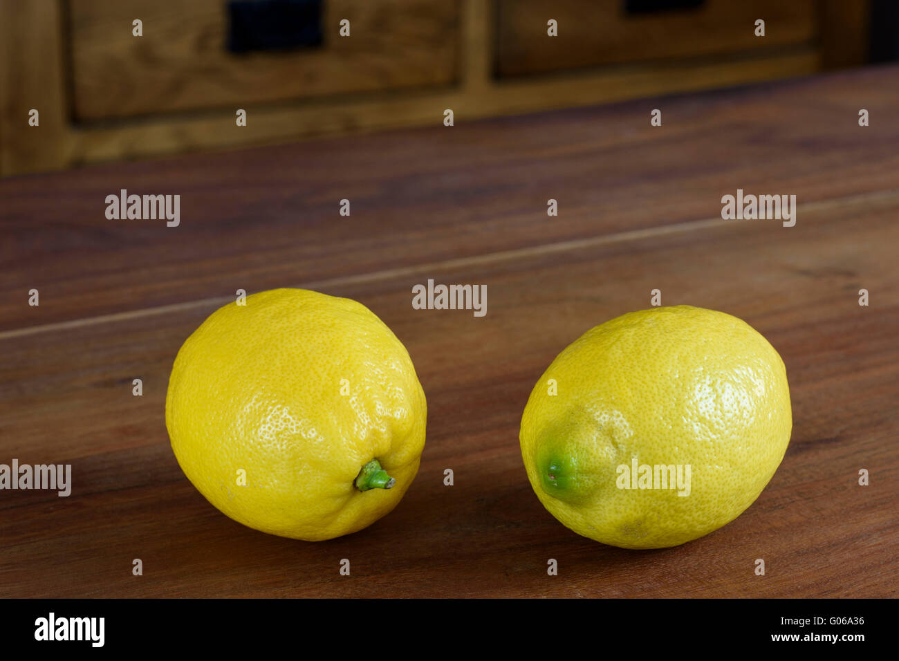 Paar ganze Zitronen auf einer hölzernen Tischplatte Stockfoto