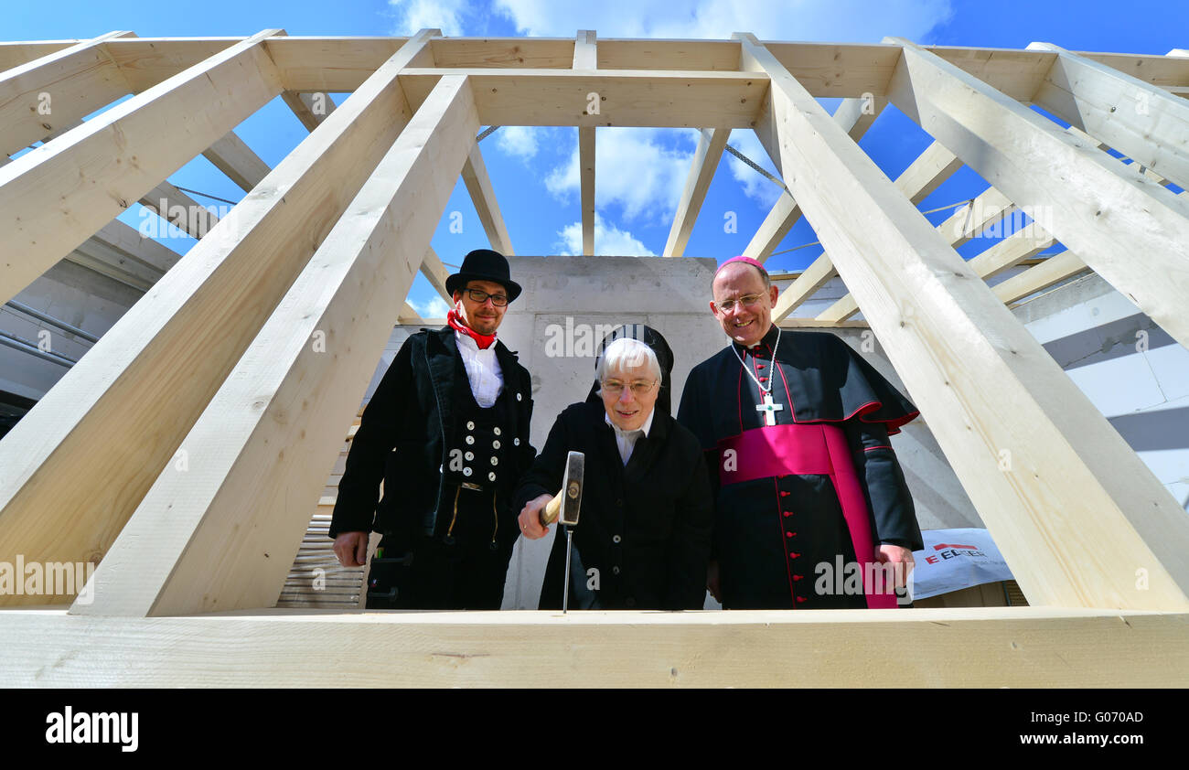 Die Mutter Oberin der Ursulinen Abtei, Schwester Angela, hämmert den letzten Nagel in den Strahl des neuen Klosters Gebäude neben Bishop Ulrich Neymeyr (R) und Tischler Lars Schrickel in Erfurt, Deutschland, 29. April 2016. Der Neubau steht neben der alten Abtei der Ursulinen, die war zu groß und unbequem für die im Alter von neun Nonnen. Das Bistum Erfurt investiert rund 2,5 Millionen Euro für den Abriss der Vorgängerbau, Neubau, Außenanlagen, die Fassade der Abtei und archäologischen Ausgrabungen. Ursulinen lebe seit 1667 in Erfurt. Foto: MARTIN SCHUTT/dp Stockfoto