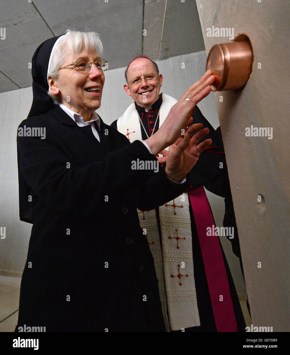 Die Mutter Oberin der Ursulinen Abtei, Schwester Angela, versinkt der Wand während der Spatenstich für das neue Kloster Gebäude neben Bischof Ulrich Neymeyr in Erfurt, Deutschland, 29. April 2016 eine Metall-Kapsel. Der Neubau steht neben der alten Abtei der Ursulinen, die war zu groß und unbequem für die im Alter von neun Nonnen. Das Bistum Erfurt investiert rund 2,5 Millionen Euro für den Abriss der Vorgängerbau, Neubau, Außenanlagen, die Fassade der Abtei und archäologischen Ausgrabungen. Ursulinen lebe seit 1667 in Erfurt. Foto: MARTIN SCHUTT/dpa Stockfoto