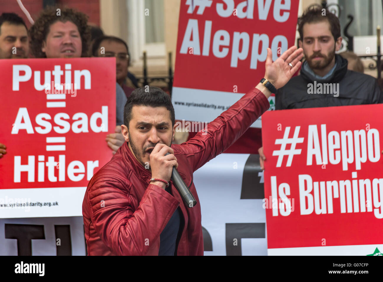 London, UK. 30. April 2016. Demonstranten in der Nähe der russischen Botschaft forderten ein Ende der russischen und syrische Luftangriffe auf Aleppo nach ein Überfall auf das Al-Qudus Krankenhaus letzte Mittwoch Nacht Zehntausende Zivilisten, einschließlich Kinder und drei Ärzte getötet. Ein Mann führt Chanten vor Poster "Putin = Assad = Hitler", "#Save Aleppo" und "#Aleppo is Burning". Peter Marshall/Alamy Live-Nachrichten Stockfoto