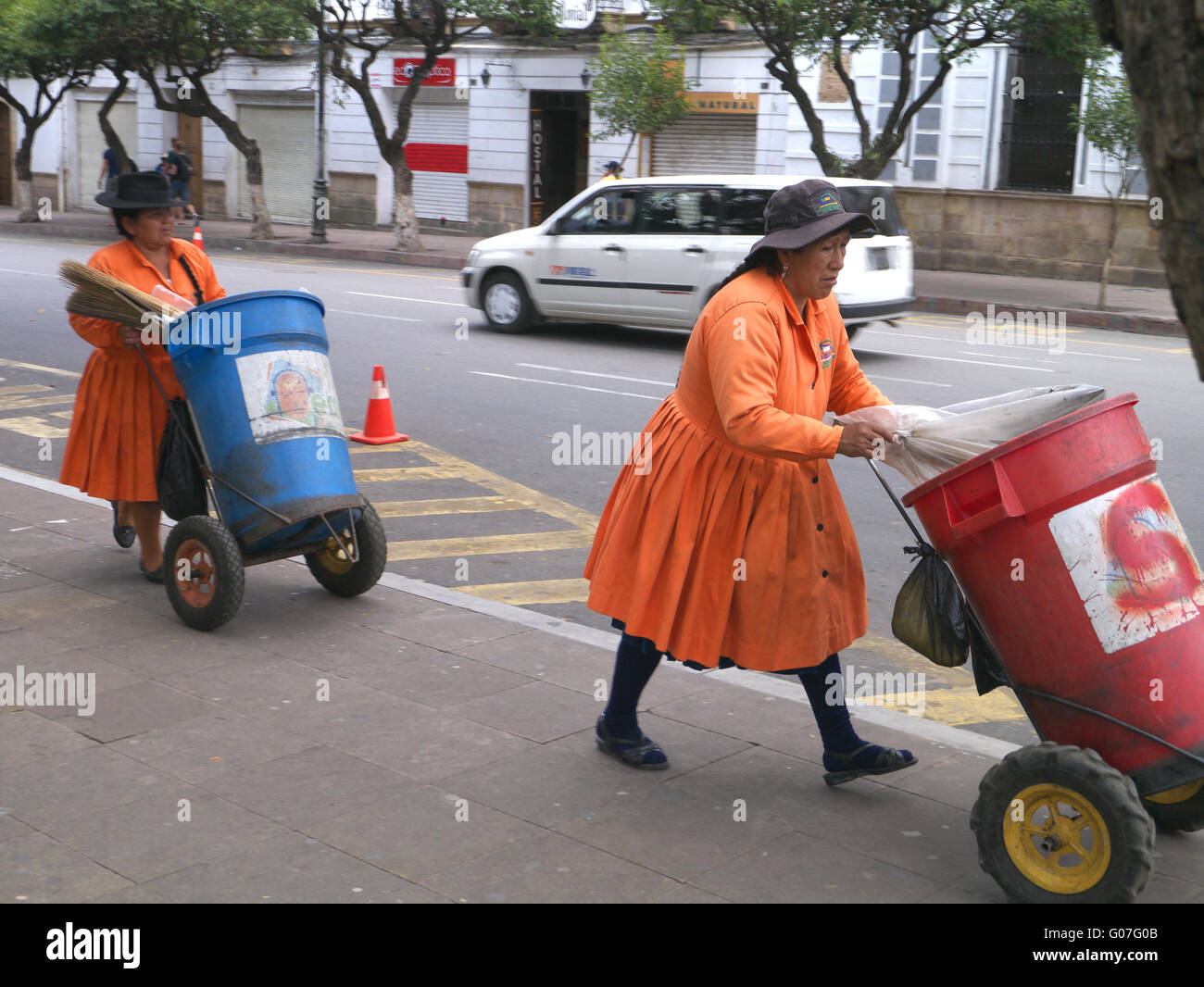 Zwei bolivianische Frauen gekleidet in orange Abholung Müll in Sucre Bolivien Stockfoto