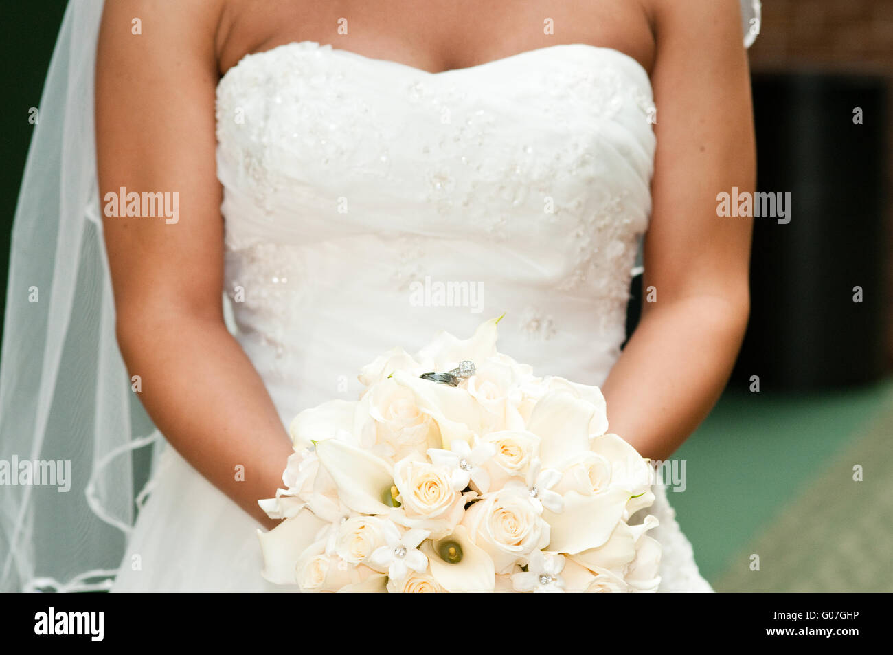 Braut hält Blumenstrauss mit Trauringe. Stockfoto