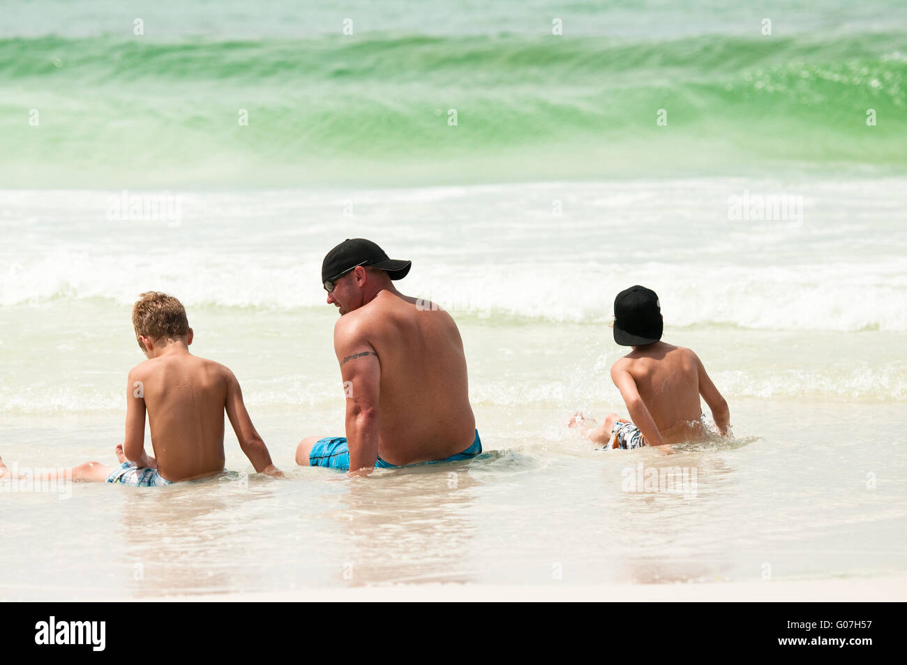 Vater und Söhne am Strand Stockfoto