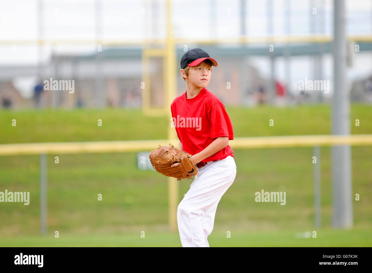 Jugend Baseball Pitcher im roten Trikot Stockfoto