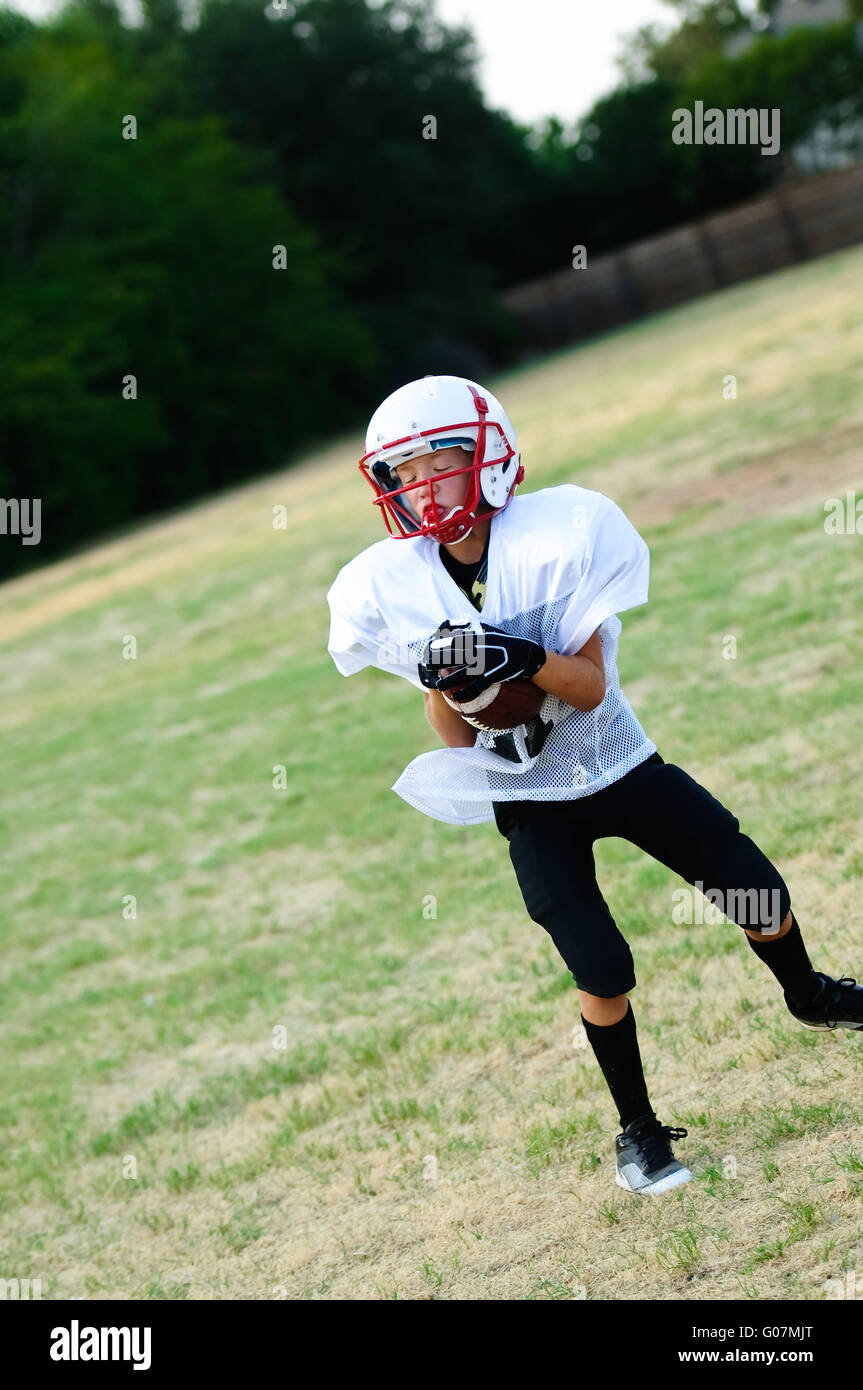 Junge Spieler fangen Fußball Stockfoto