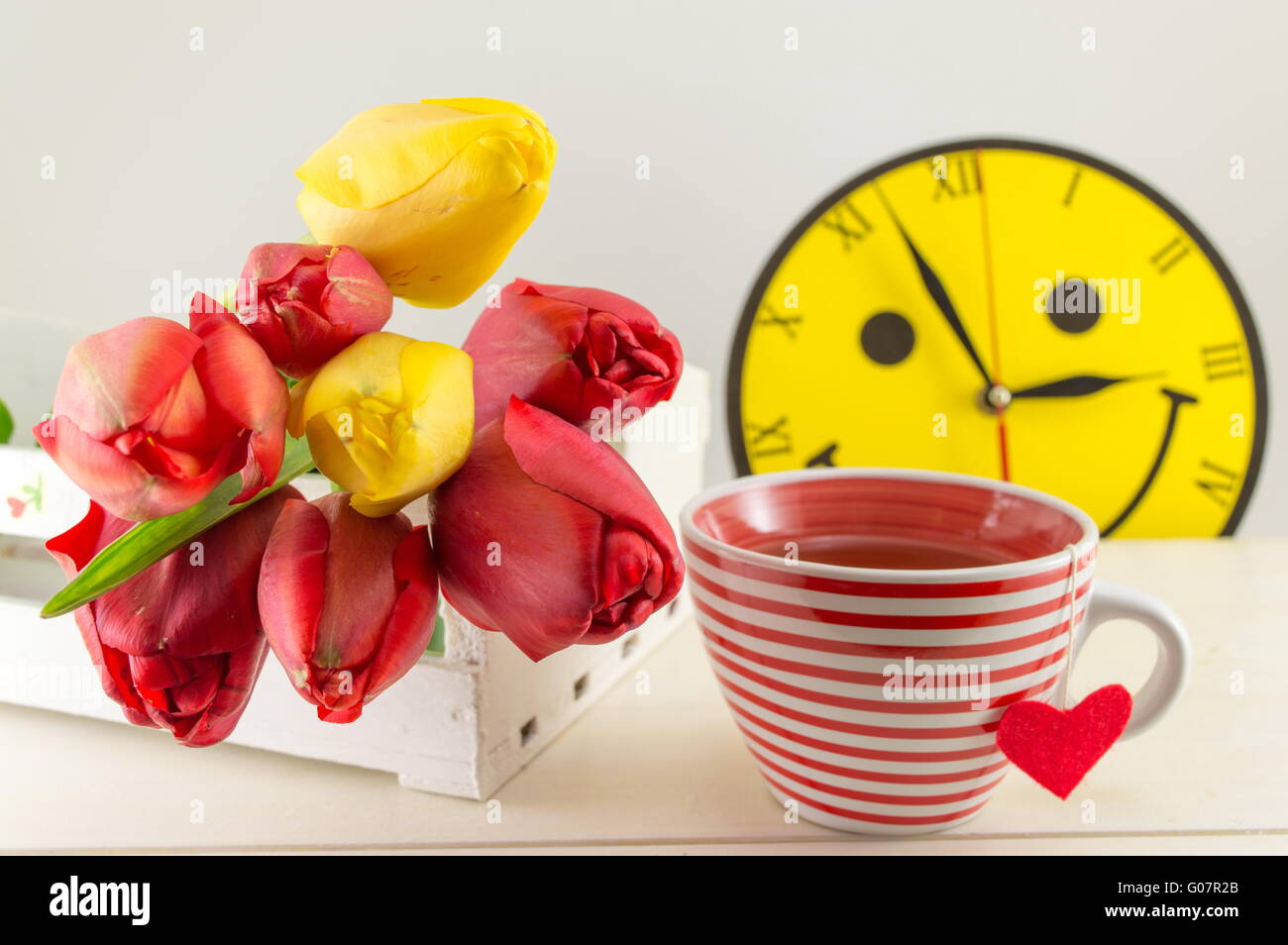 Rote und gelbe Tulpen auf einem Holztisch Stockfoto