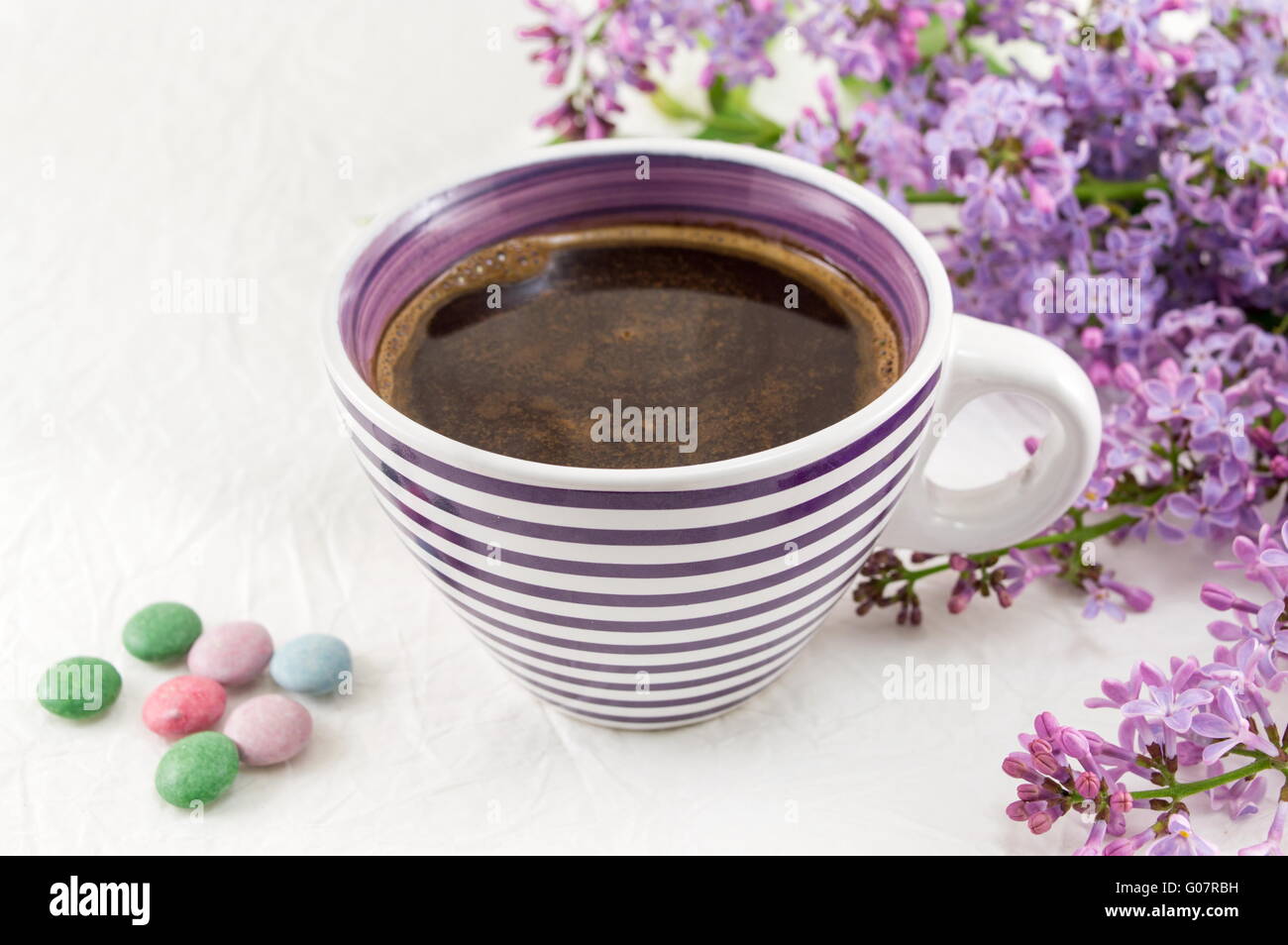 Tasse Kaffee und lila Blumen Stockfoto