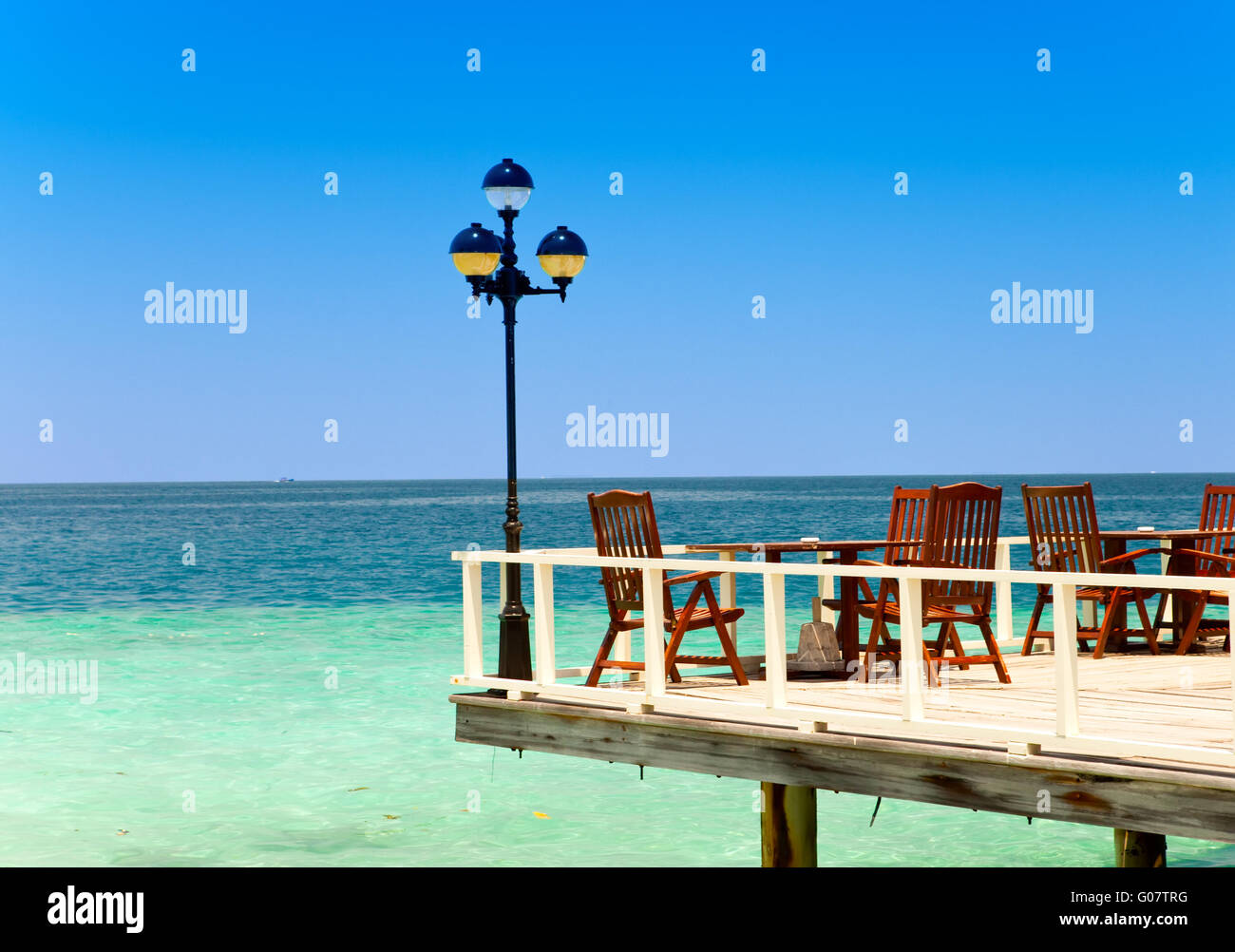 Hölzerne Plattform über dem Meer, Sessel und ein lant Stockfoto