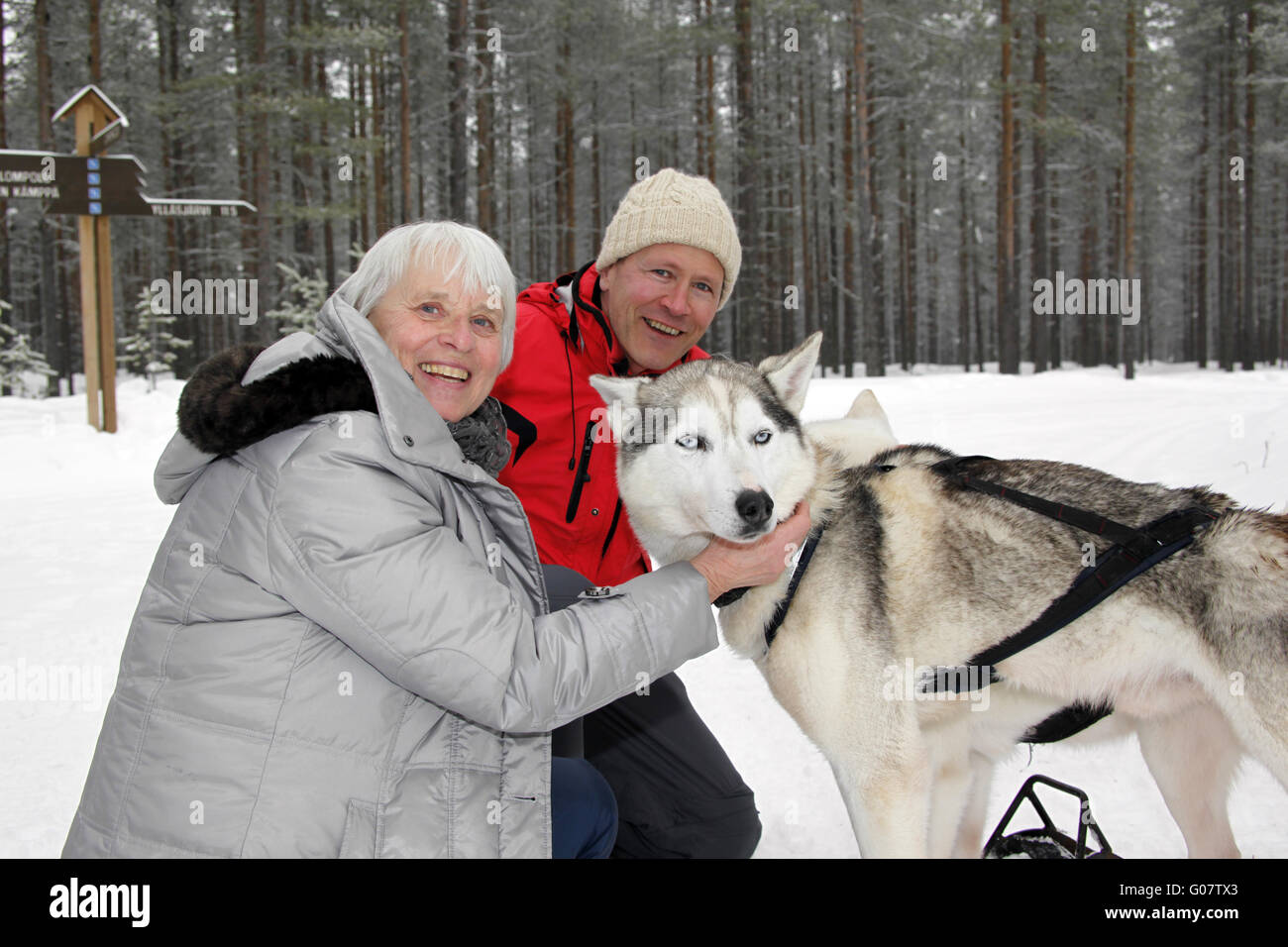Mann und Frau kuscheln mit Siberian Husky Stockfoto