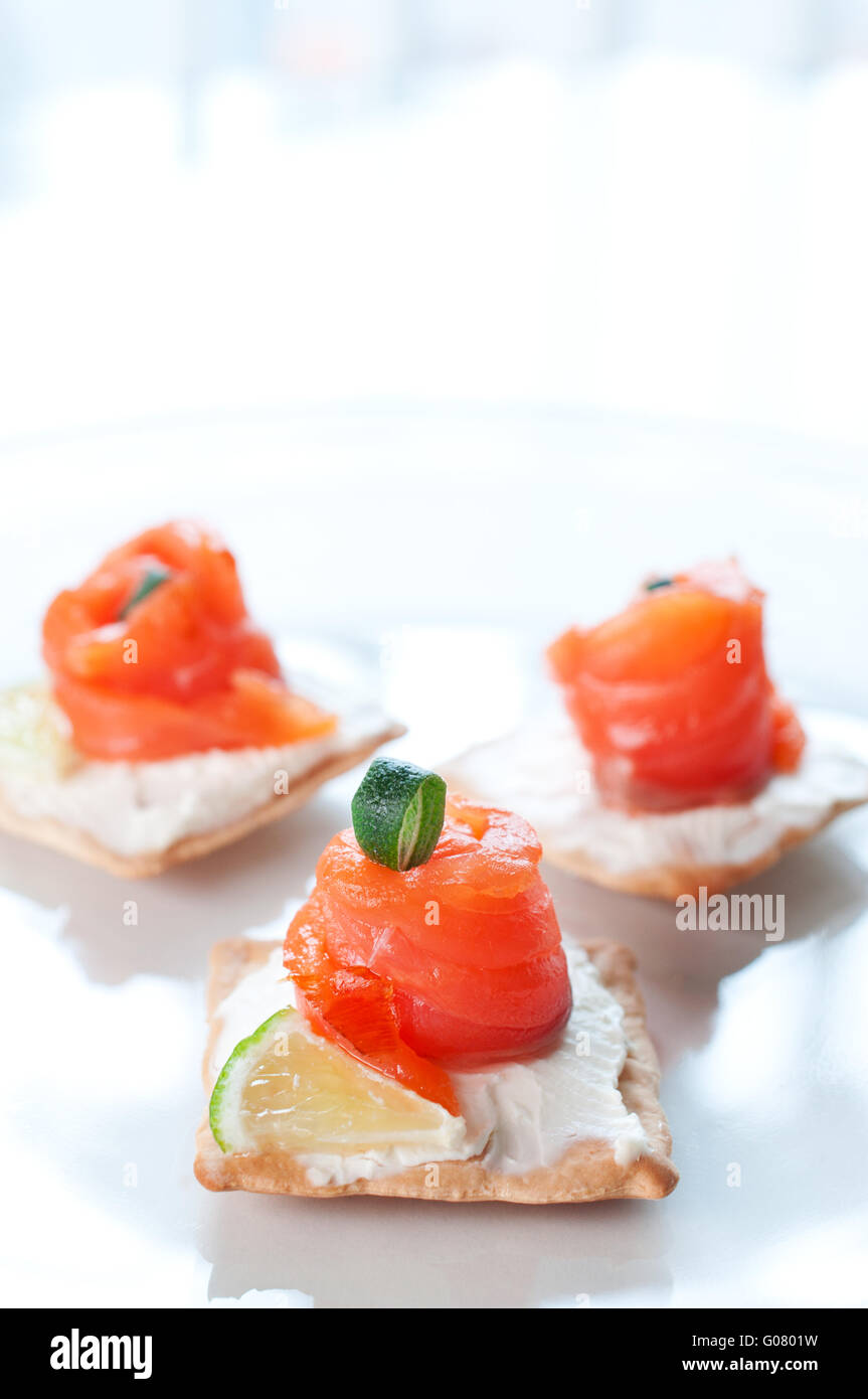 Kanapees mit geräuchertem Lachs und Frischkäse auf weißen Teller ...