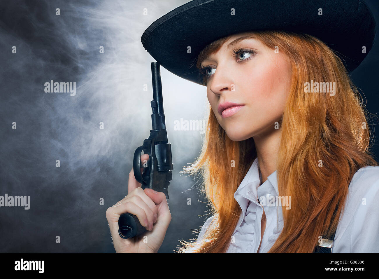 Das schöne Mädchen mit Hut, mit einem Revolver. Stockfoto
