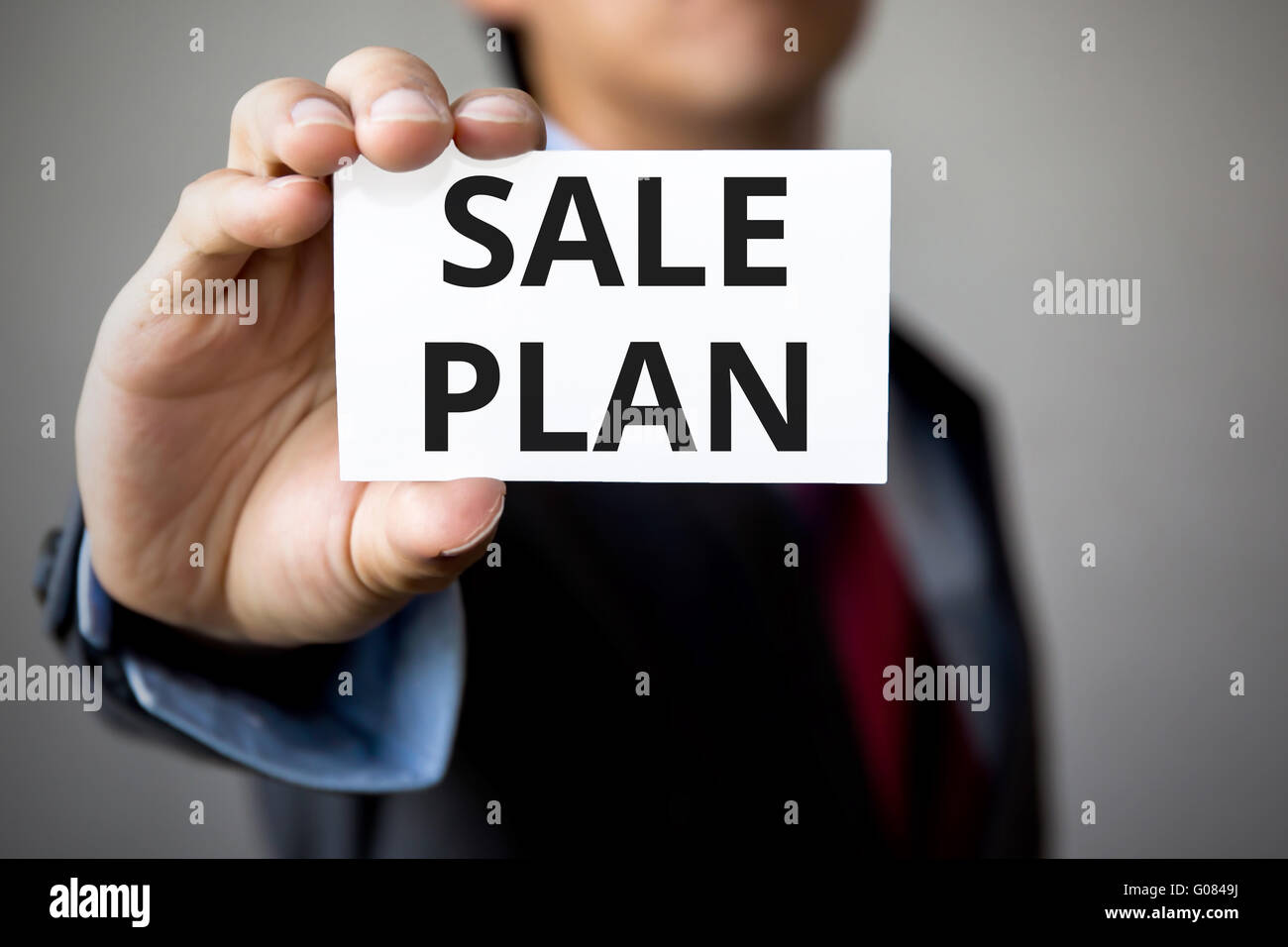 Geschäftsmann präsentiert "Verkauf-Plan" Wort auf weißem Karton. Stockfoto