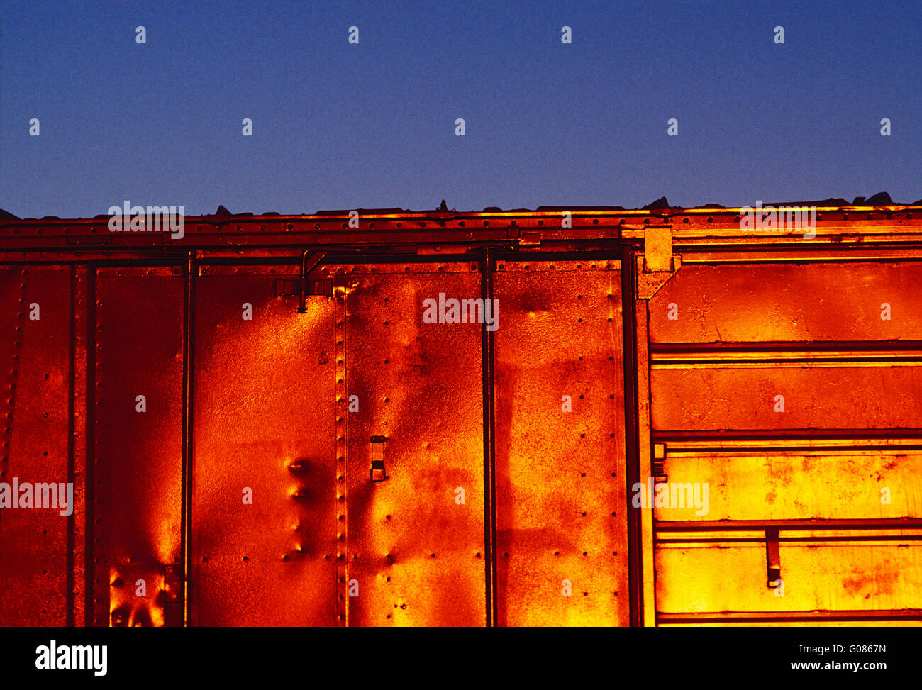 Untergehende Sonne spiegelt aus Güterzug Auto Stockfoto