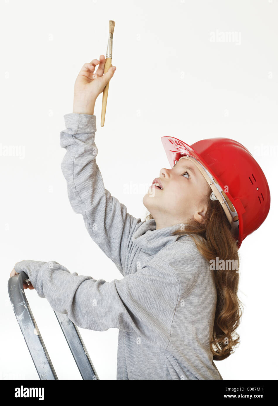 Mädchen in der Arbeitshelm mit einem Pinsel. Stockfoto