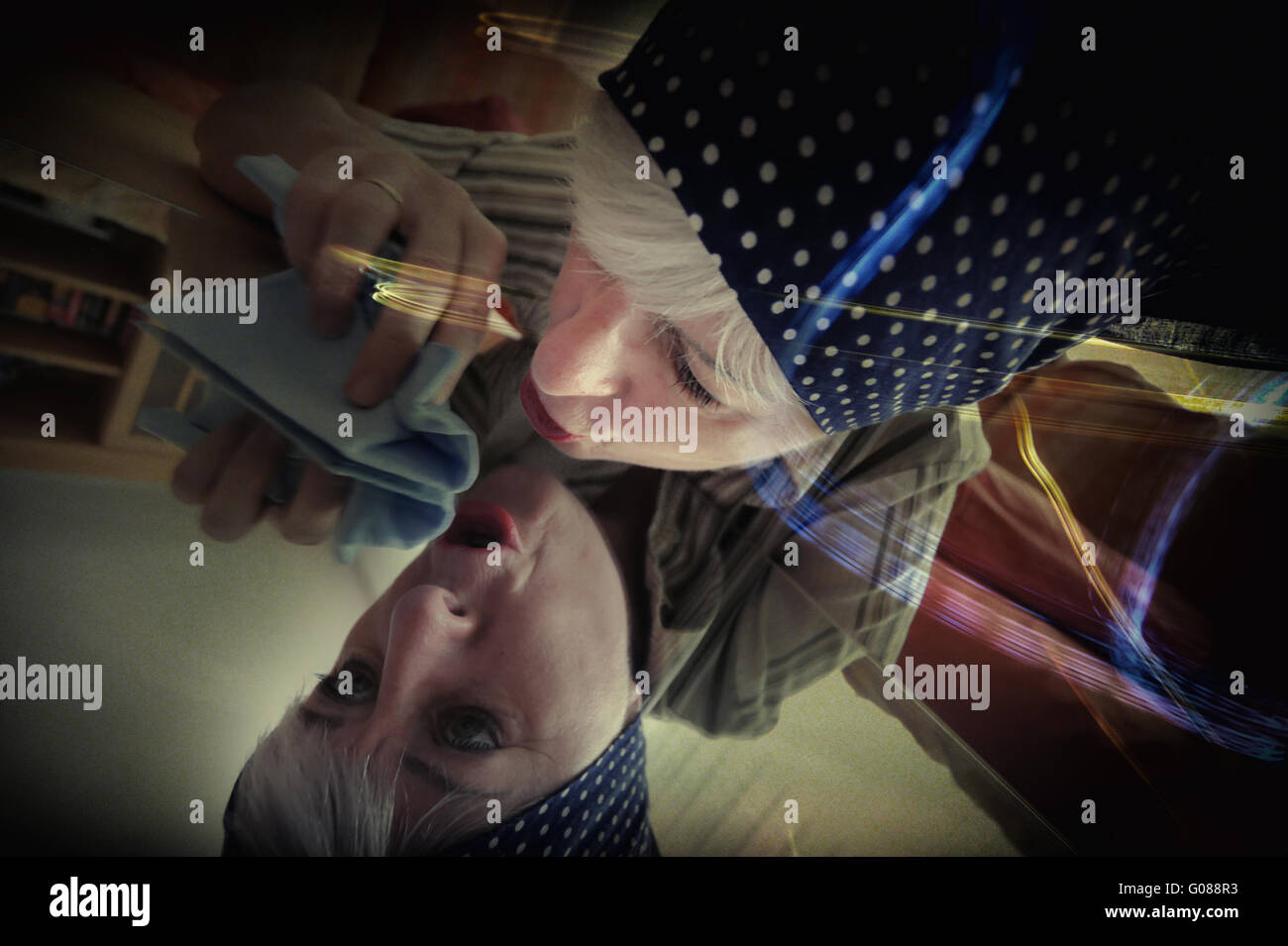 eine Hausfrau spiegelt sich in der Tabelle Reinigung Stockfoto