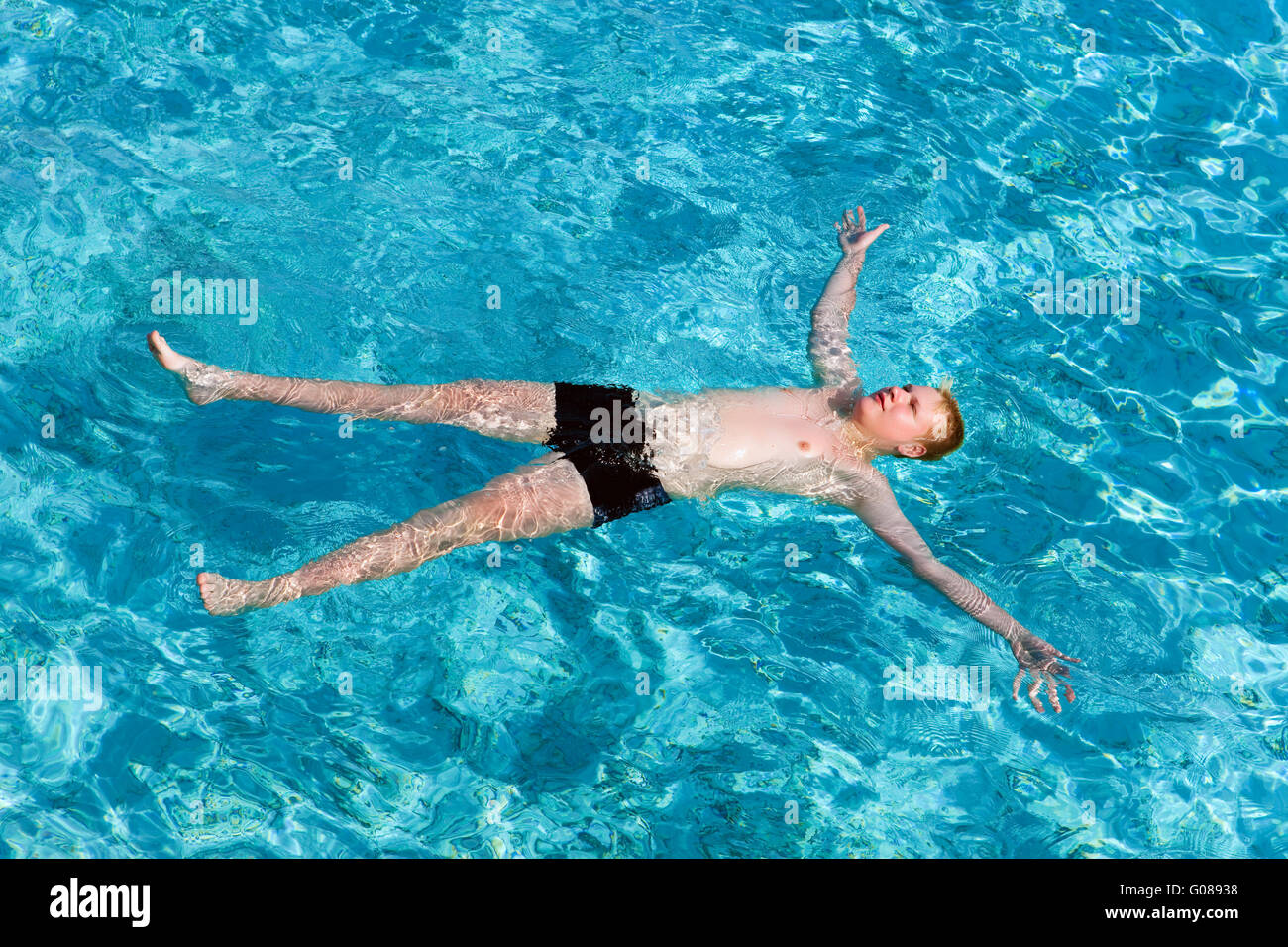 Teenager hat einen Rest auf türkisfarbenem kristallklarem Wasser Stockfoto