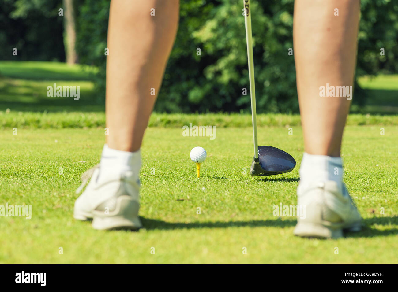 Beine eines Golfers mit Golfball und Golfschläger Stockfoto