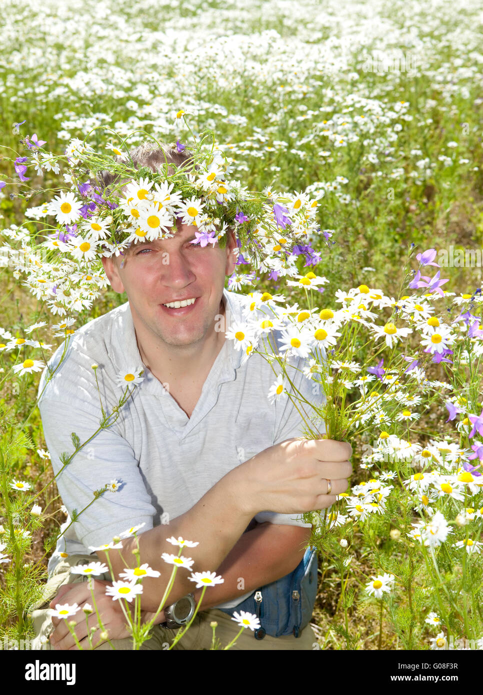 Lächelnder Mann in einem Kranz von Wildblumen Stockfoto
