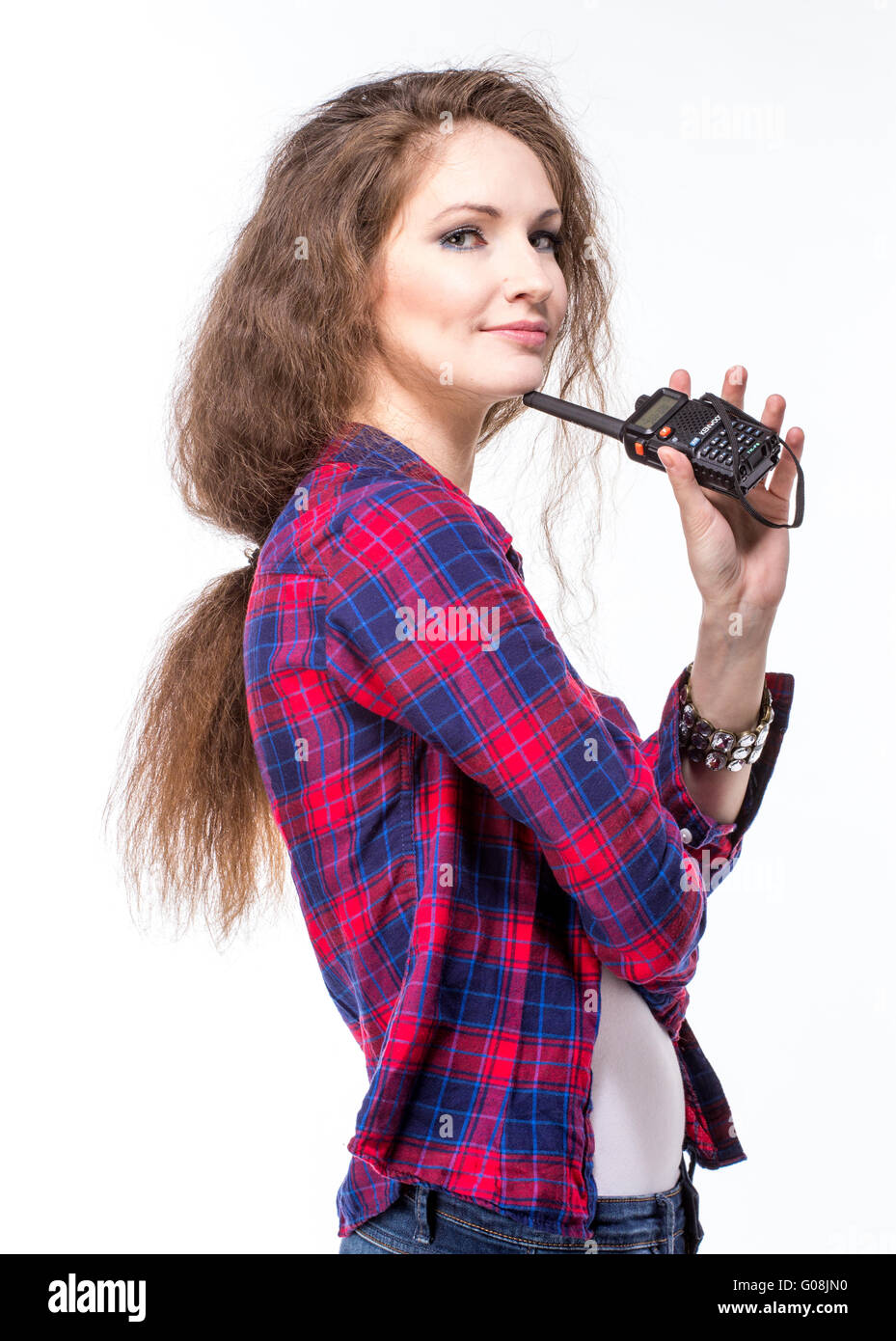 Attraktive junge Frau im karierten Hemd mit Walkie-Talkie Stockfoto