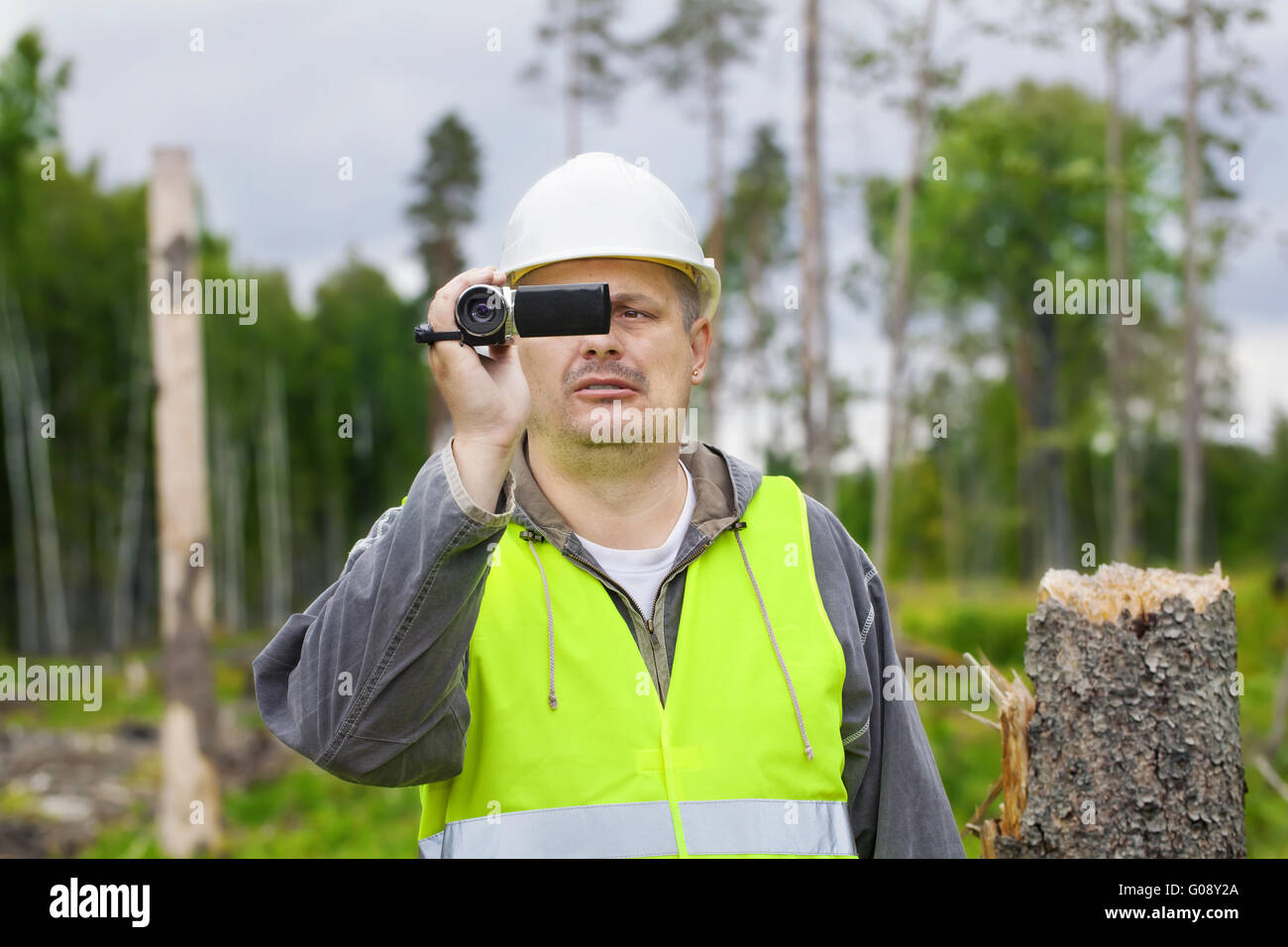 Wald-Offizier mit Camcorder im zerstörten Wald Stockfoto