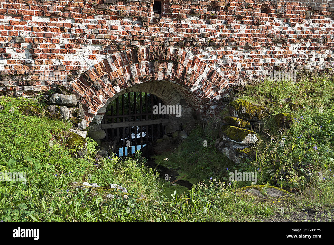 Bach fließt durch die Wand eines Klosters Stockfoto