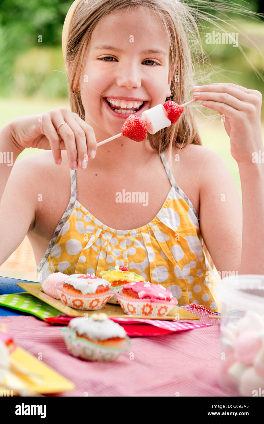Lächelndes Mädchen und einem Stick voll mit marshmallows Stockfoto