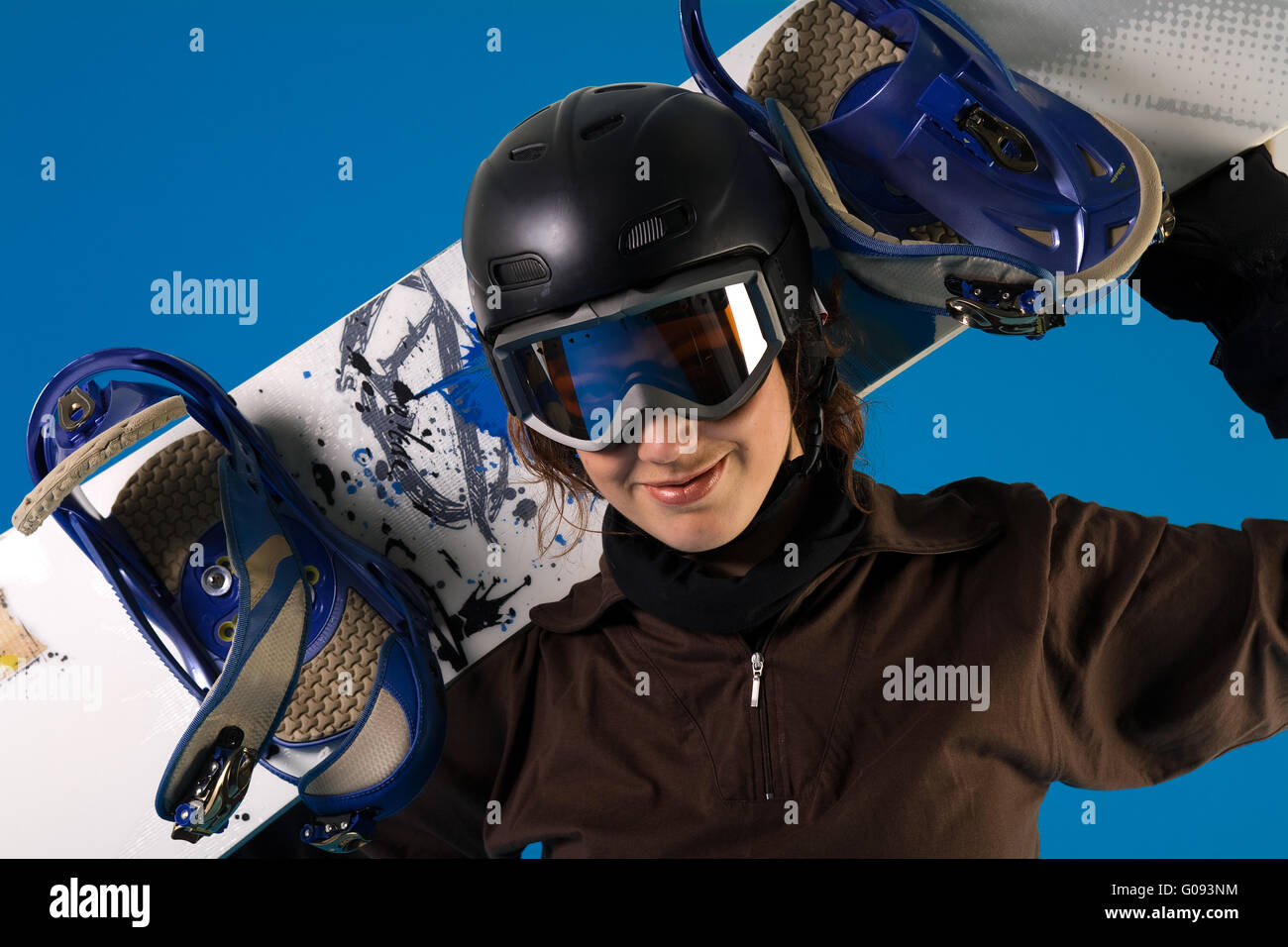 Frau mit langen lockigen Haaren mit Snowboard im Nacken Stockfoto