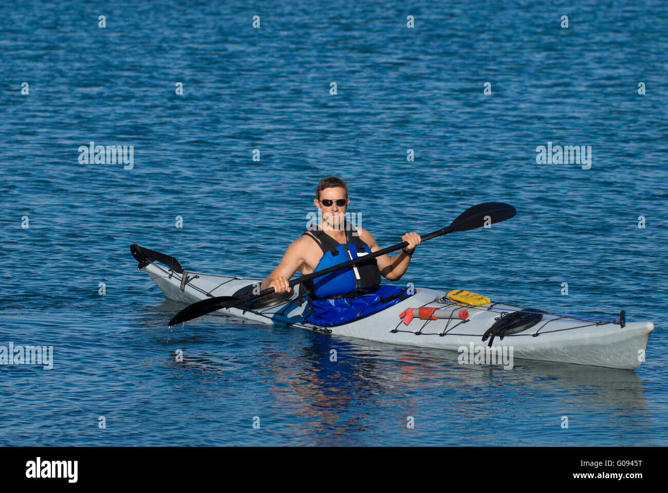 Atheltic Mann im Seekajak Stockfoto