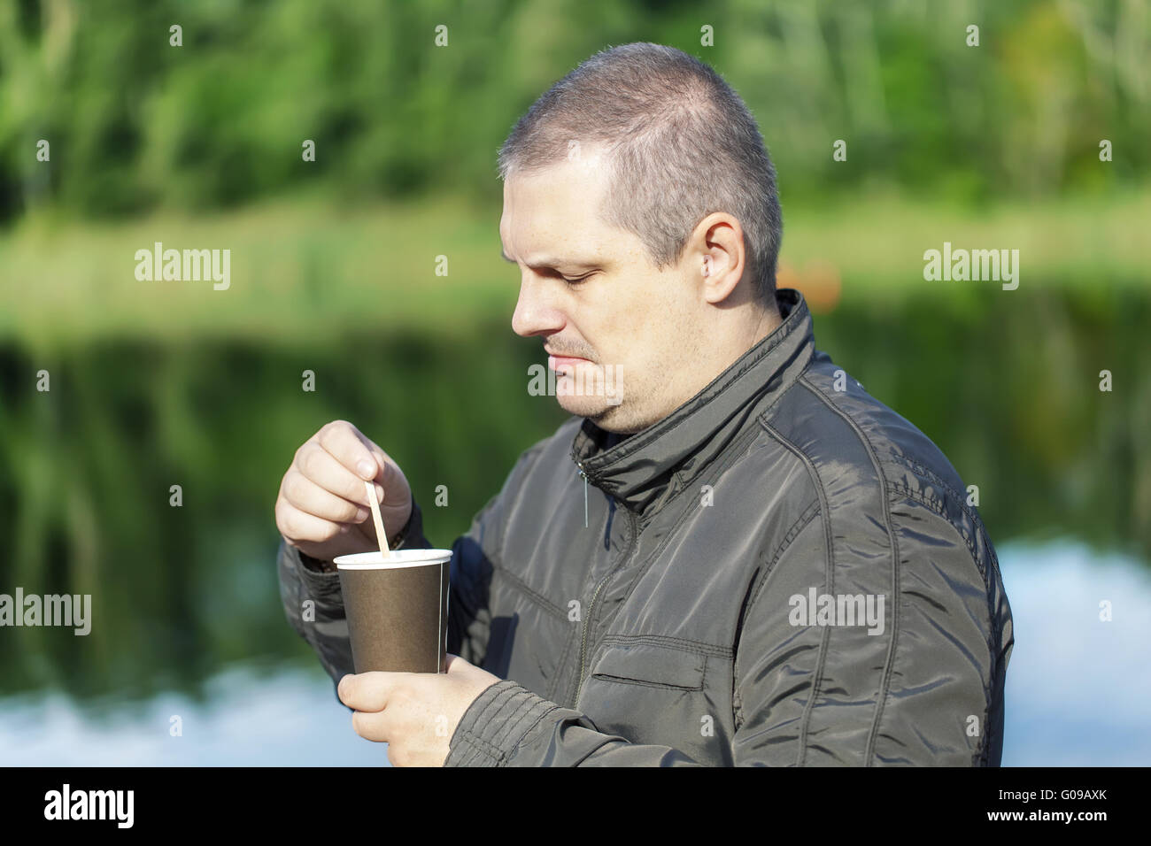 Mann mit Kaffee in der Nähe Fluss Stockfoto