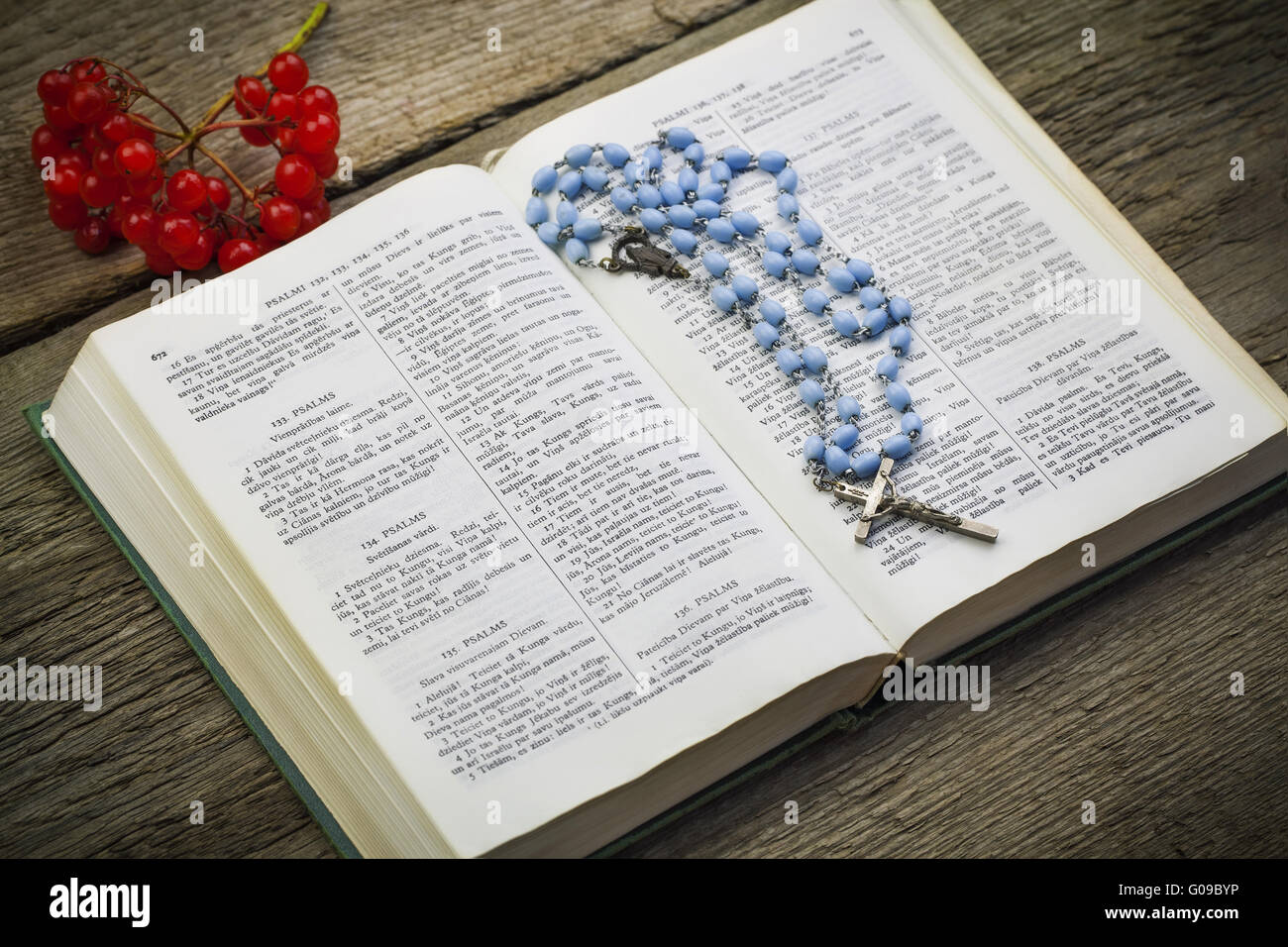 Bibel mit Rosenkranz auf Brettern Stockfoto