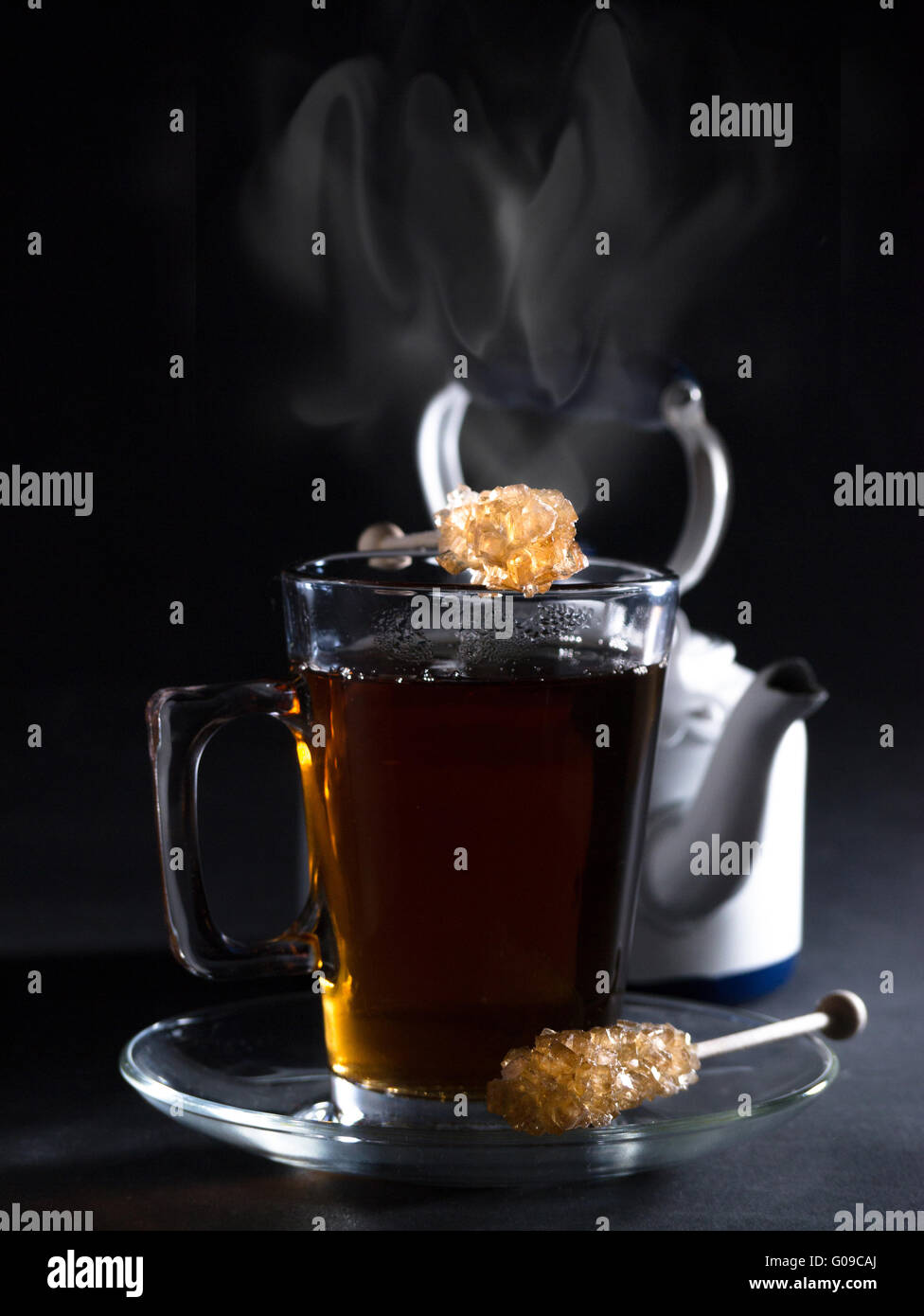 Ein Glas Tee mit einem Wasserkocher im Hintergrund Stockfoto