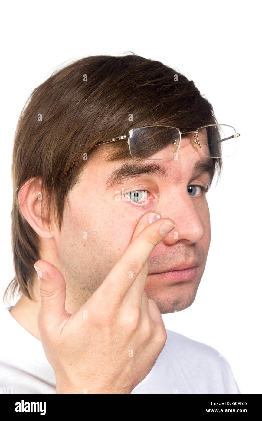 Detailansicht eines Mannes braune Augen beim Einsetzen einer korrigierenden Kontaktlinse auf dem Finger. Stockfoto