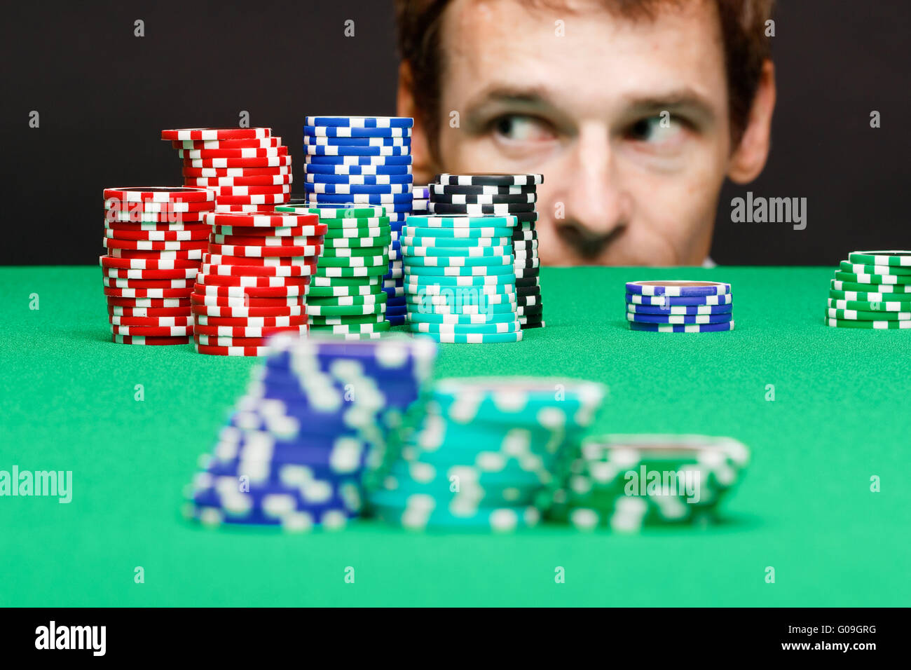 Mann unter dem Tisch auf Chips spielen Stockfoto