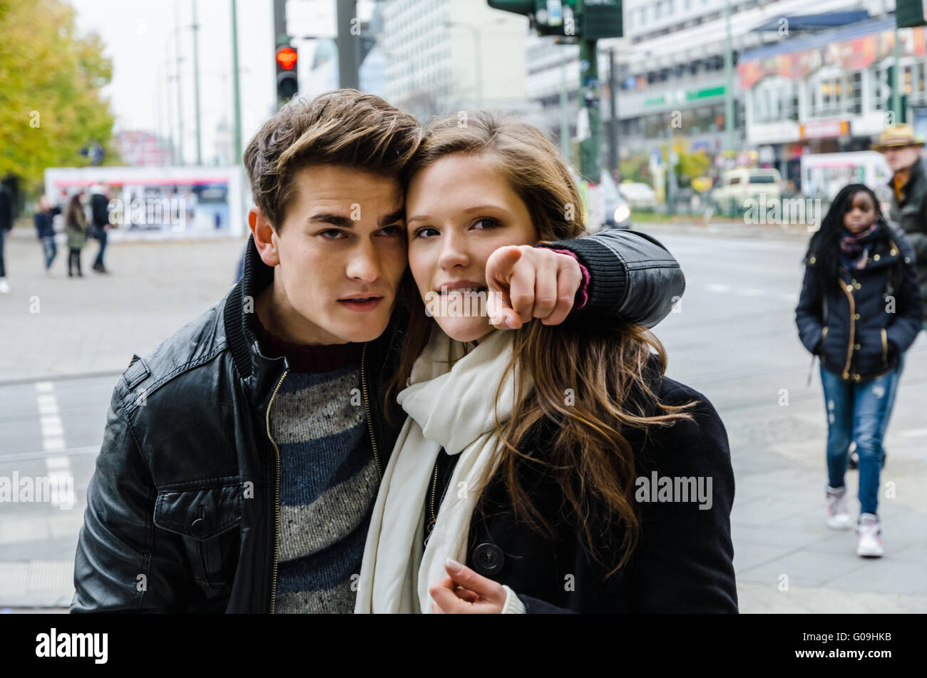 Mann zeigt etwas zu Freundin auf Stadtstraße Stockfoto