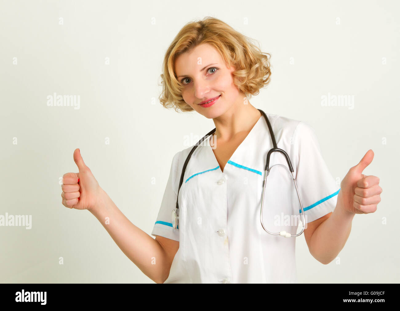Glücklich lächelnd fröhlich Ärztin mit Daumen hoch Geste Stockfoto