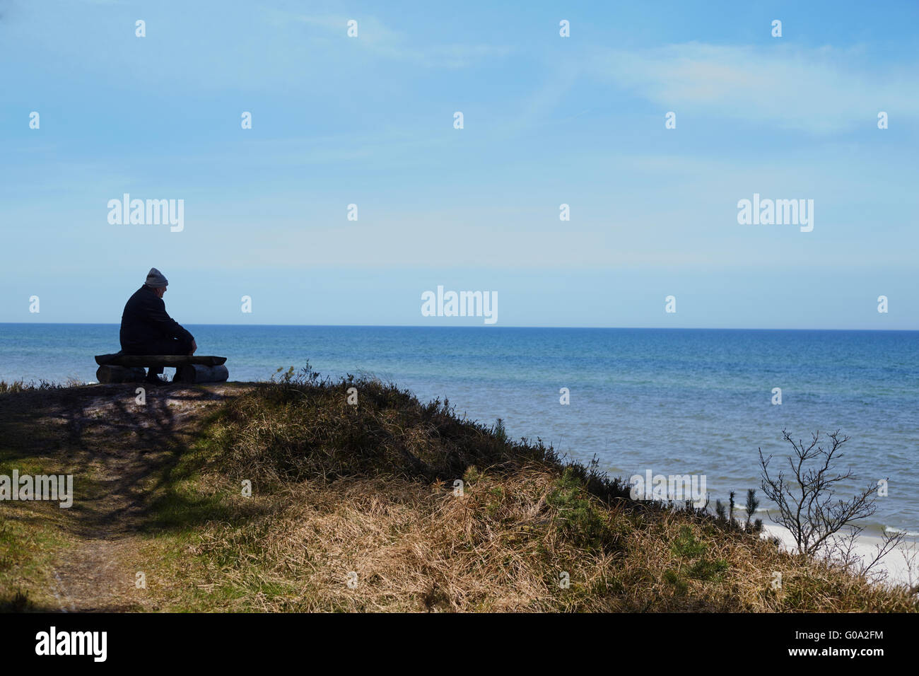 Alter Mann vor dem Meer, im Schatten sitzend Stockfoto