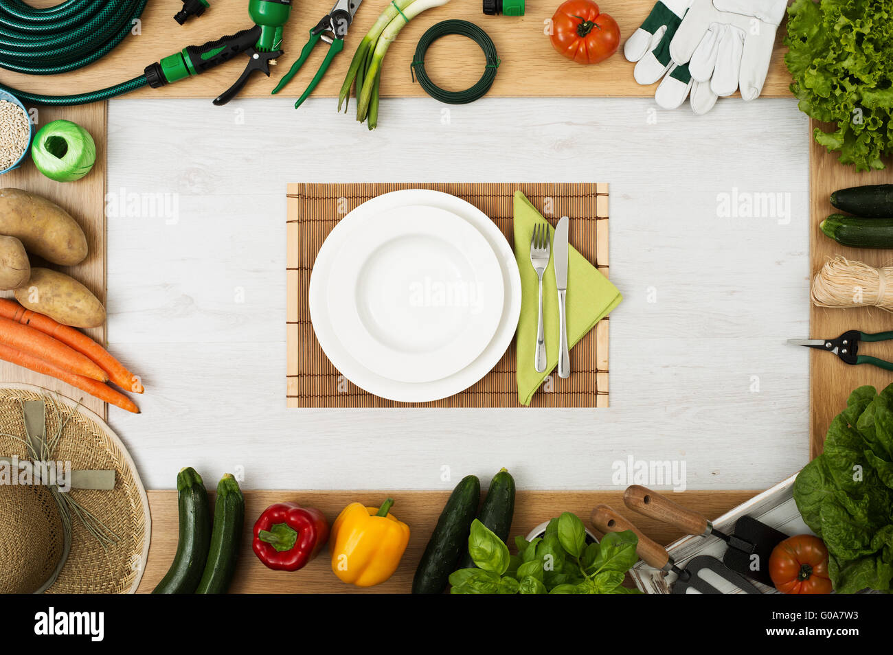 Gartenarbeit, Werkzeuge und frisches Gemüse, ein Bild zu komponieren, stellen Tisch in Mitte mit Teller, Gabel und Messer, Ansicht von oben Stockfoto