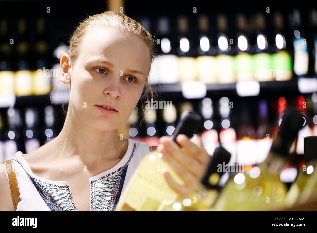 Frau shopping für Alkohol in einer Flasche Shop Stockfoto