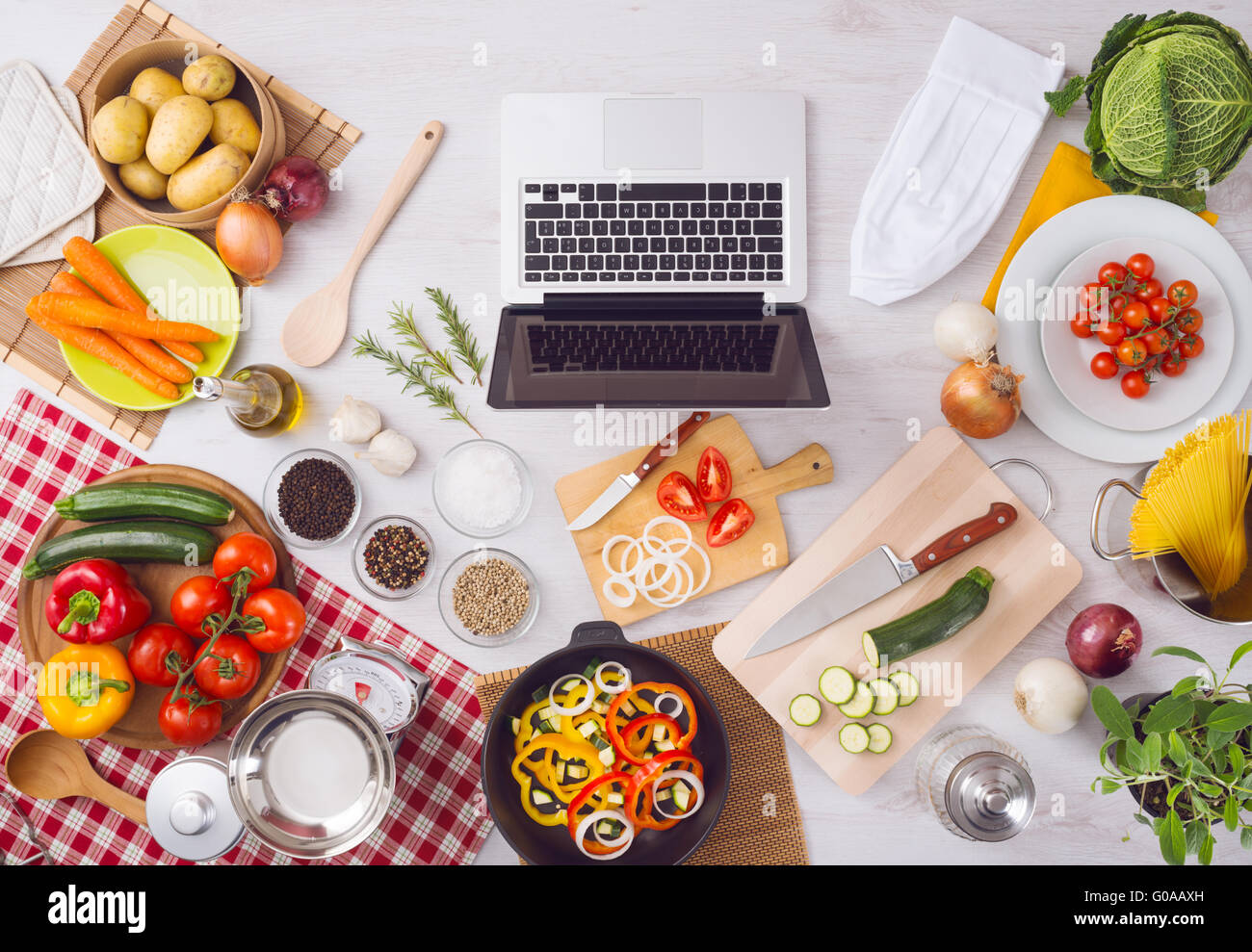 Küche zu Hause Table-Top Aussicht mit Laptop, Lebensmittelzutaten, rohes Gemüse, Geschirr und Besteck, Ansicht von oben Stockfoto