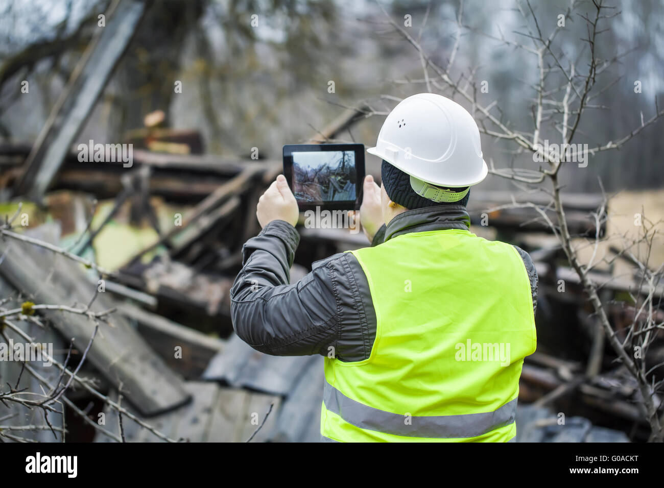 Inspektor mit Tablet-PC in der Nähe von eingestürzten Gebäudes Stockfoto