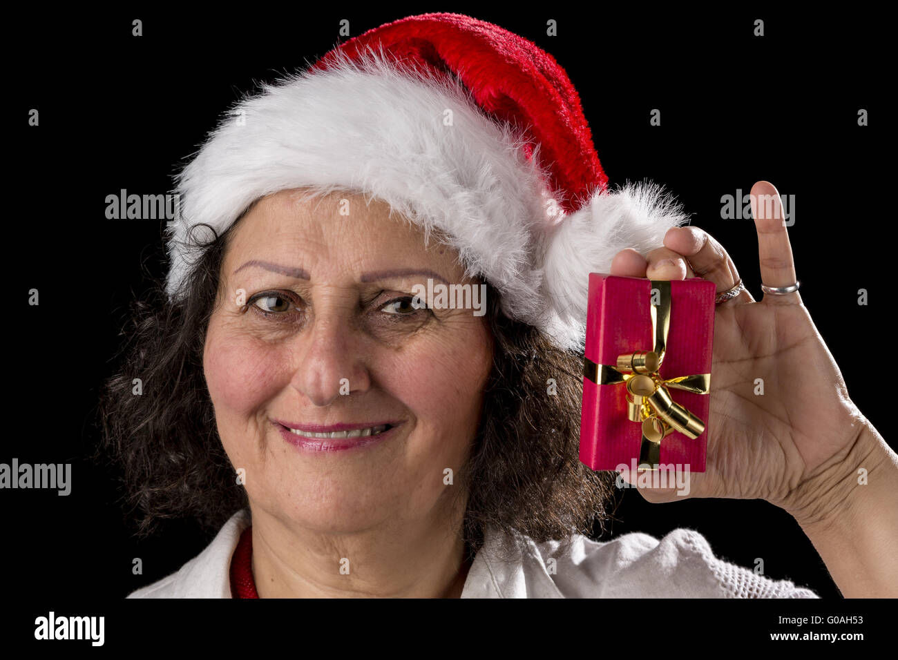 Ehrwürdige Frau mit roter Mütze hält kleines Geschenk Stockfoto