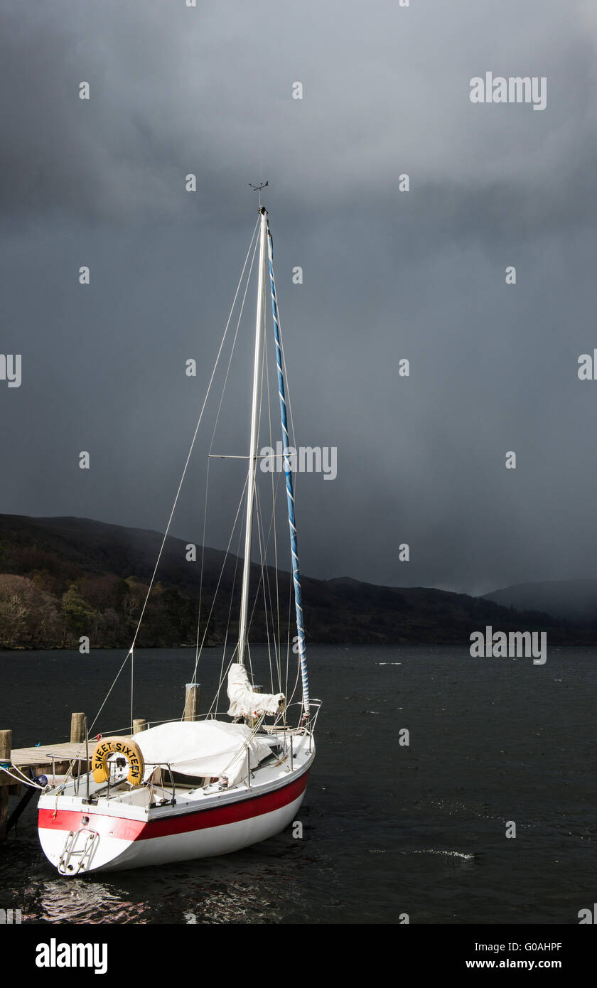 Weiße Yacht gegen ein broody, Moody, dunklen und stürmischen Himmel auf Ullswater im Lake District, Cumbria im Norden von England Stockfoto