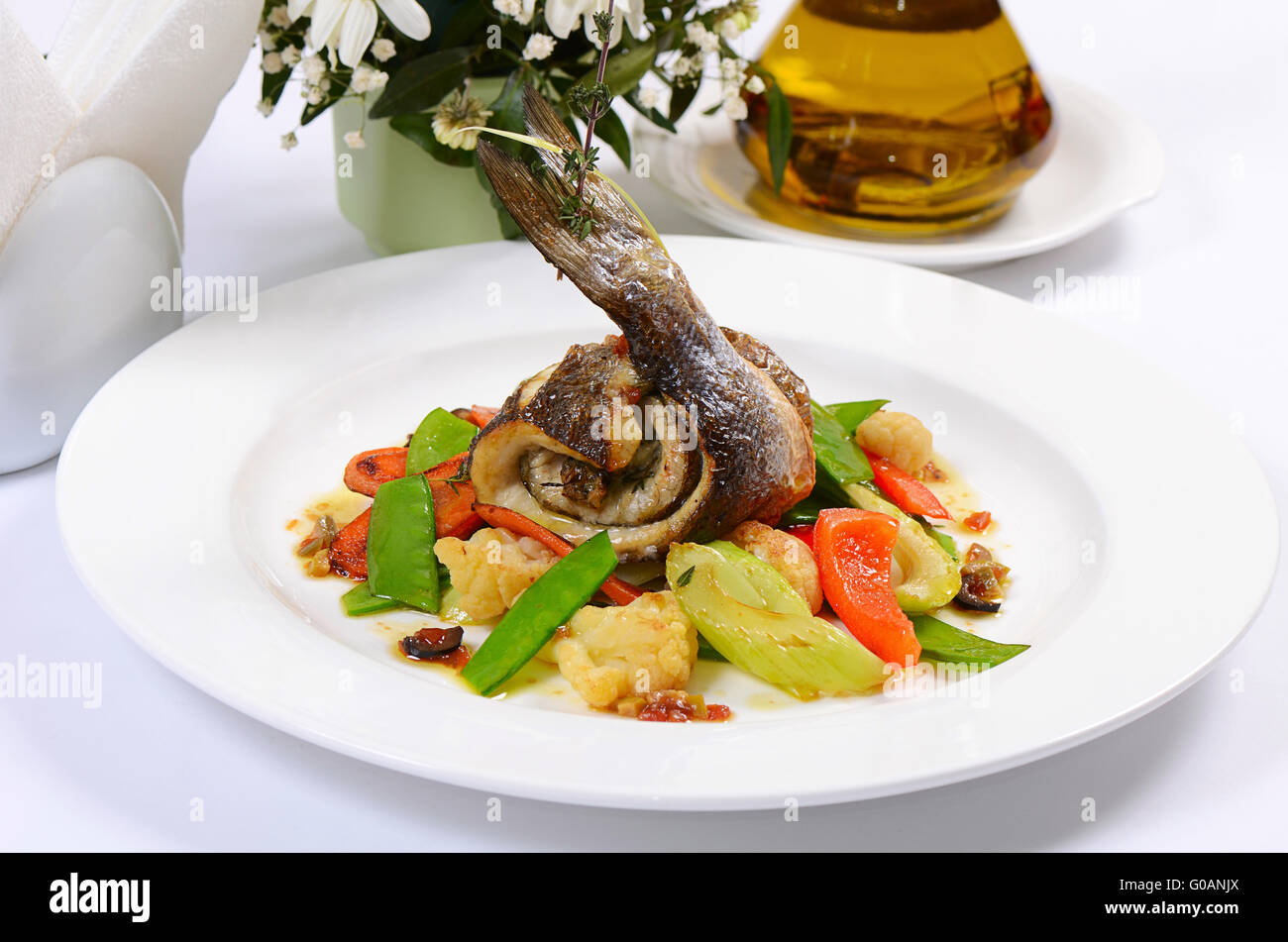 Wolfsbarschfilet mit Frühlingsgemüse und Oliven-sauce Stockfoto